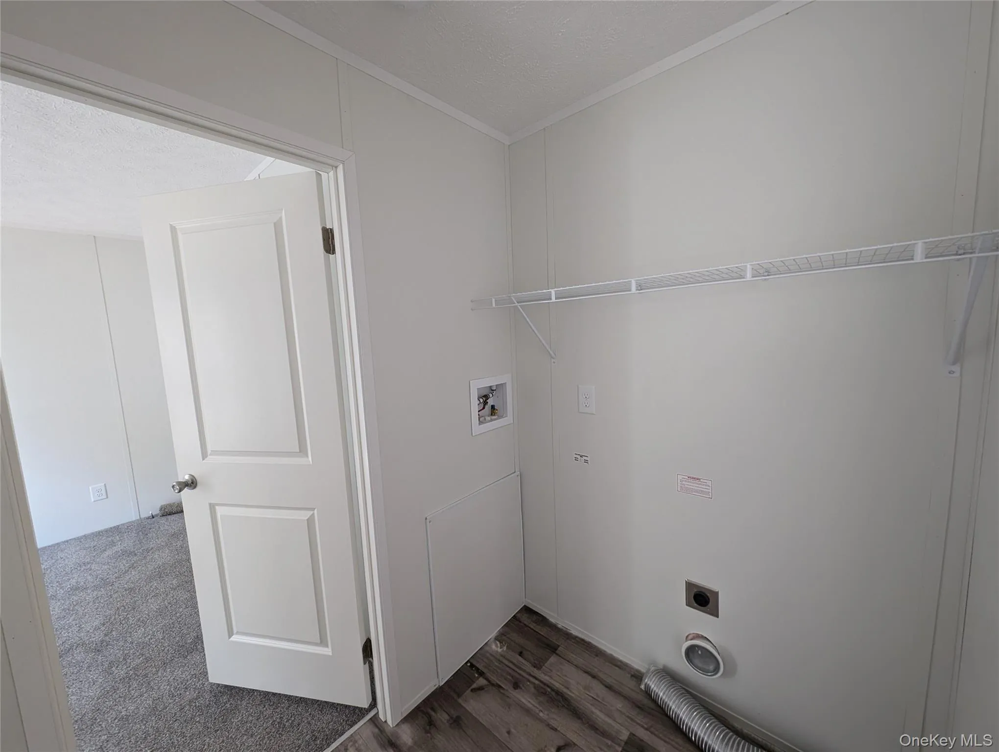 Laundry area featuring crown molding, laundry area, hookup for a washing machine, hookup for an electric dryer, and dark wood-style floors Laundry area featuring crown molding, laundry area, hookup for a washing machine, hookup for an electric dryer, and dark wood-style floors