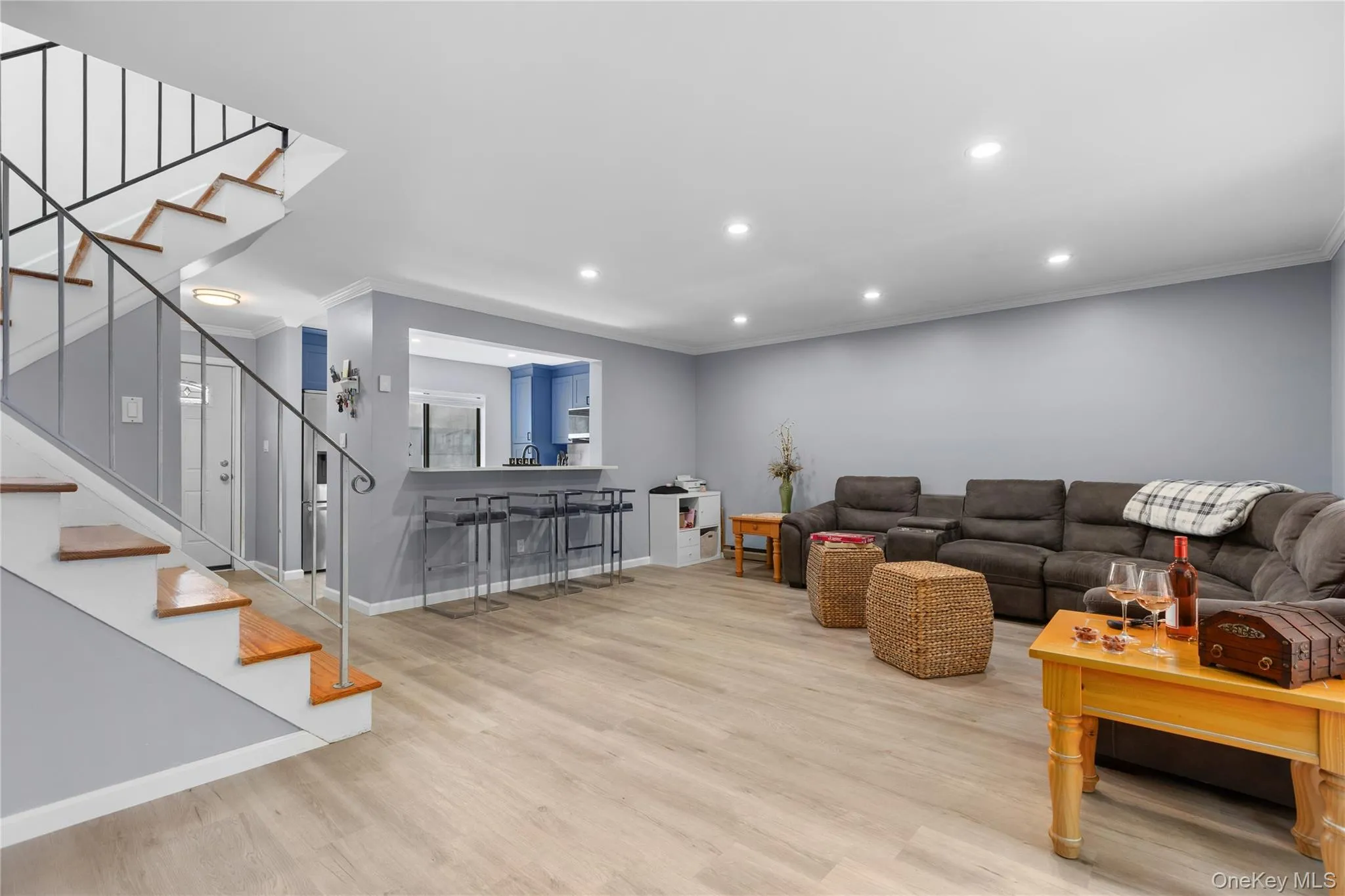 Spacious living area featuring light vinyl flooring, recessed lighting and access to stairs leading to second floor Spacious living area featuring light vinyl flooring, recessed lighting and access to stairs leading to second floor