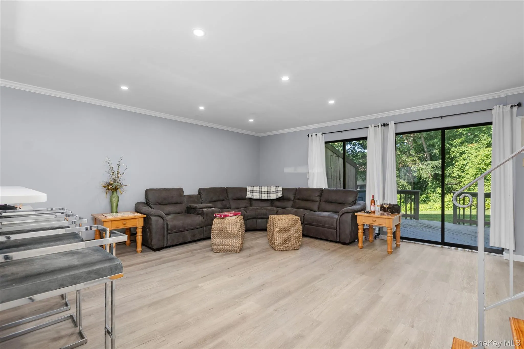 Spacious living area featuring light vinyl flooring, recessed lighting and access to deck Spacious living area featuring light vinyl flooring, recessed lighting and access to deck