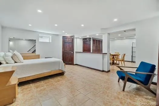 Spacious interior featuring ceramic tile flooring, recessed lighting, and a dark wood paneled door Spacious interior featuring ceramic tile flooring, recessed lighting, and a dark wood paneled door