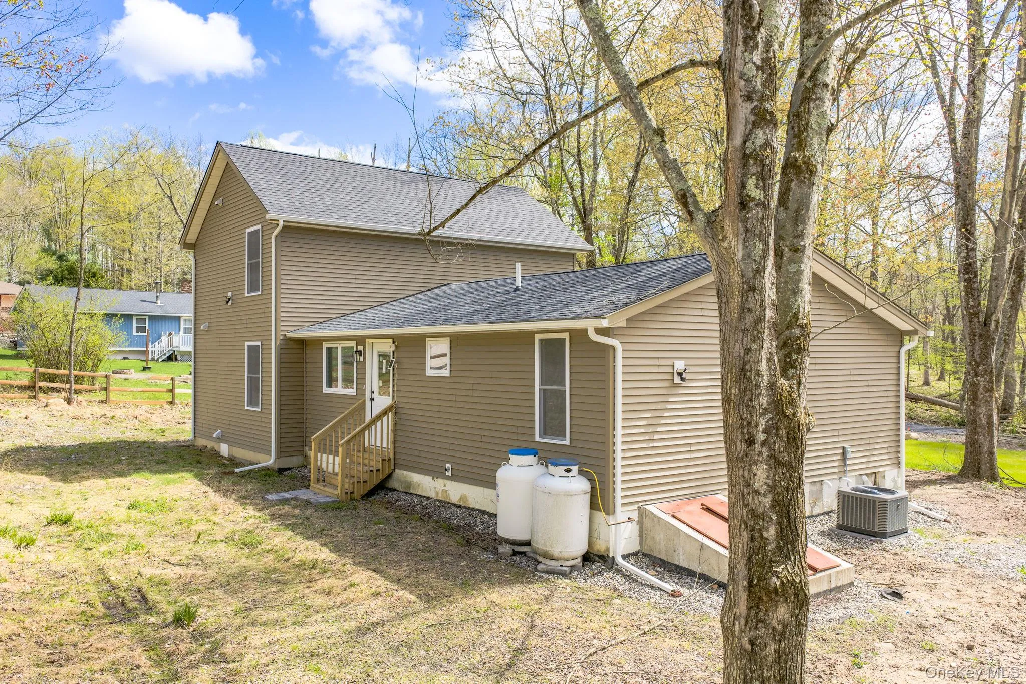Light brown siding exterior with dark shingle roofing Light brown siding exterior with dark shingle roofing