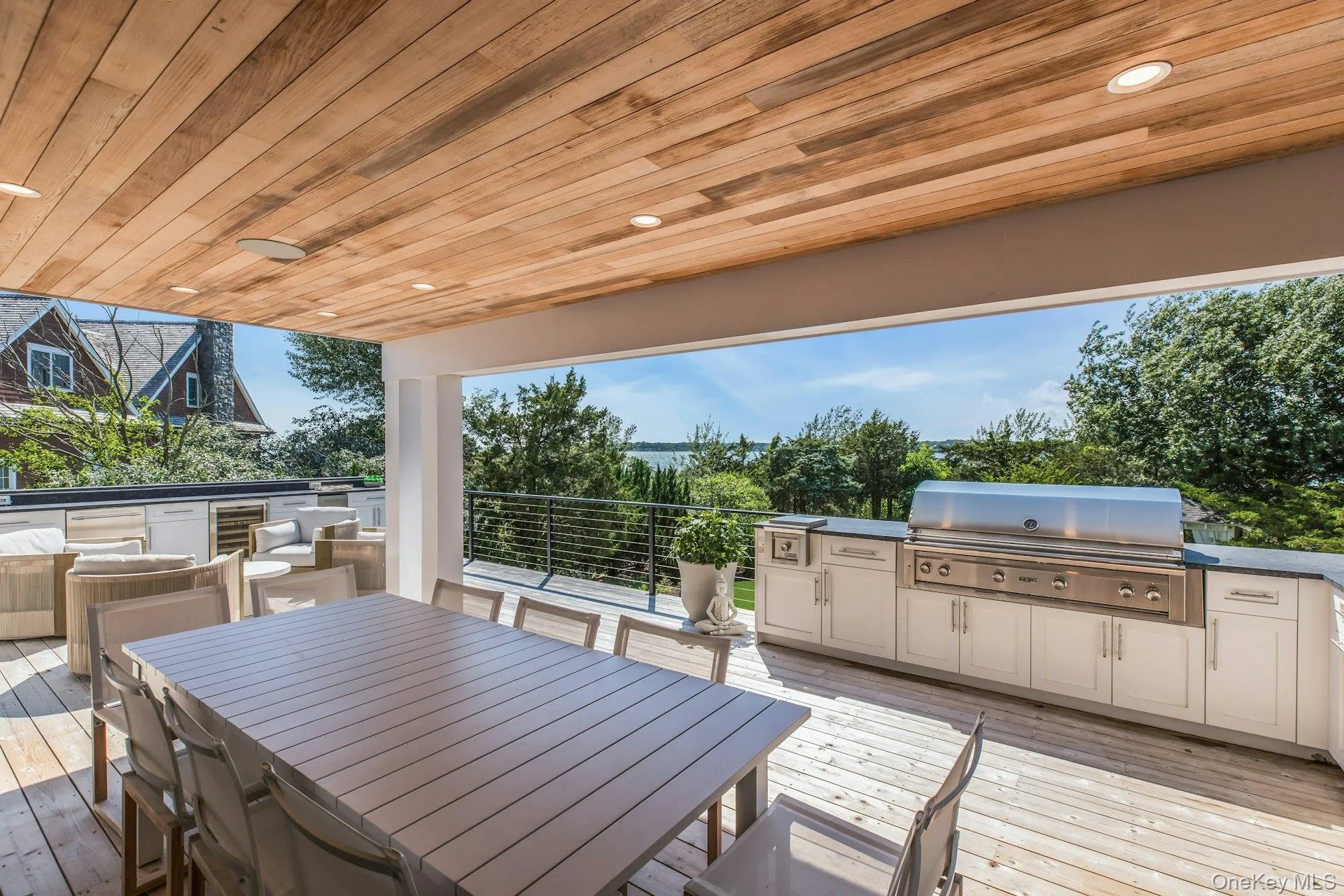 Expansive covered outdoor deck featuring a wood-finish ceiling, recessed lighting, and wood-finish flooring Expansive covered outdoor deck featuring a wood-finish ceiling, recessed lighting, and wood-finish flooring