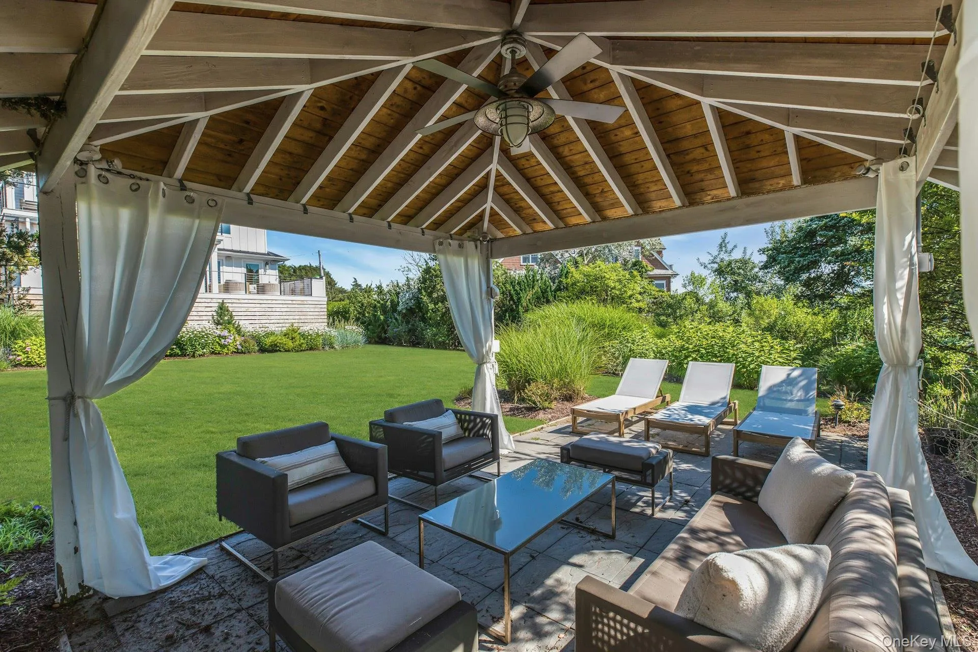 Covered patio featuring a wood-finish ceiling, central ceiling fan, and privacy drapes Covered patio featuring a wood-finish ceiling, central ceiling fan, and privacy drapes