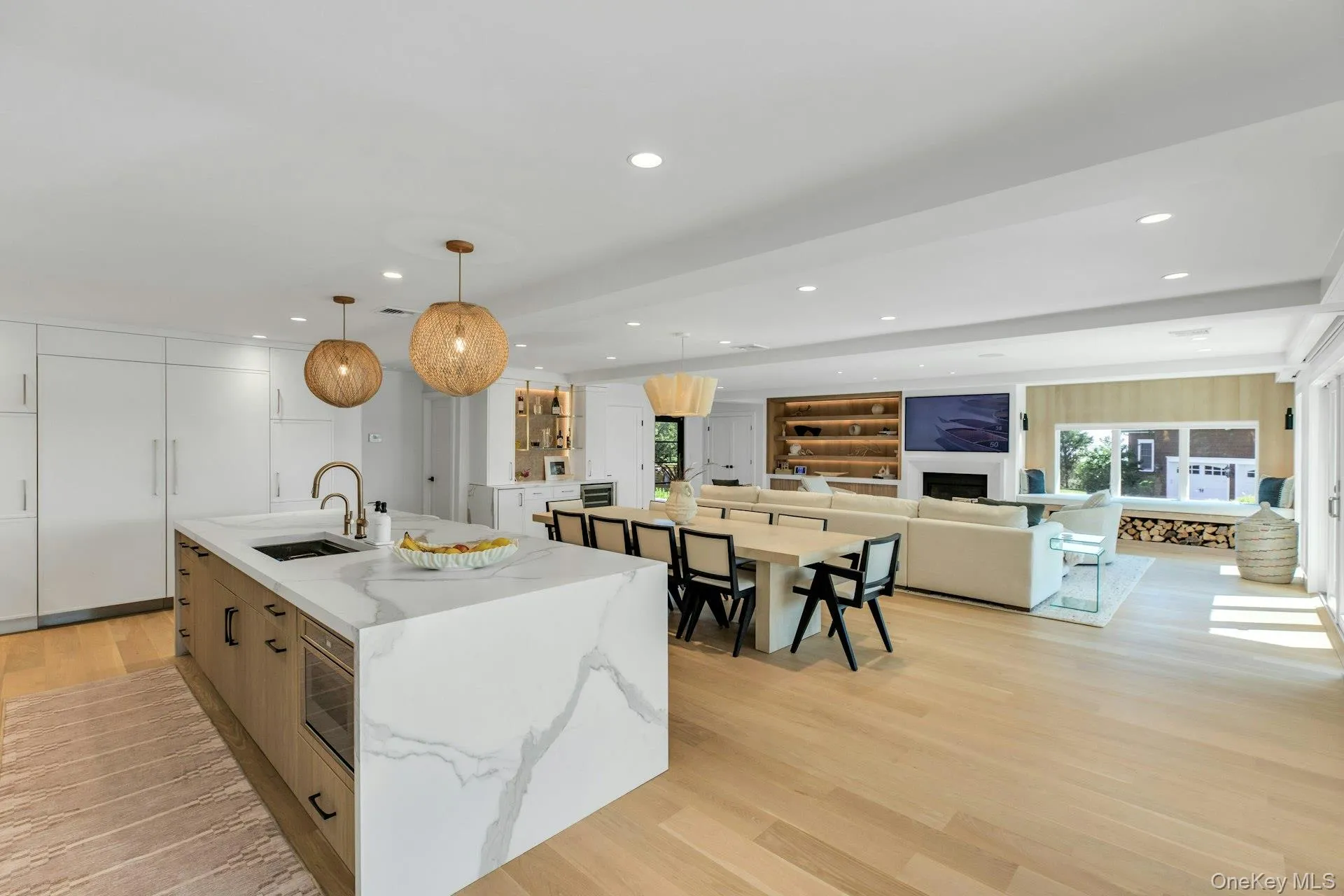 Gourmet kitchen featuring a large island with waterfall countertop, integrated sink, and modern pendant lighting Gourmet kitchen featuring a large island with waterfall countertop, integrated sink, and modern pendant lighting