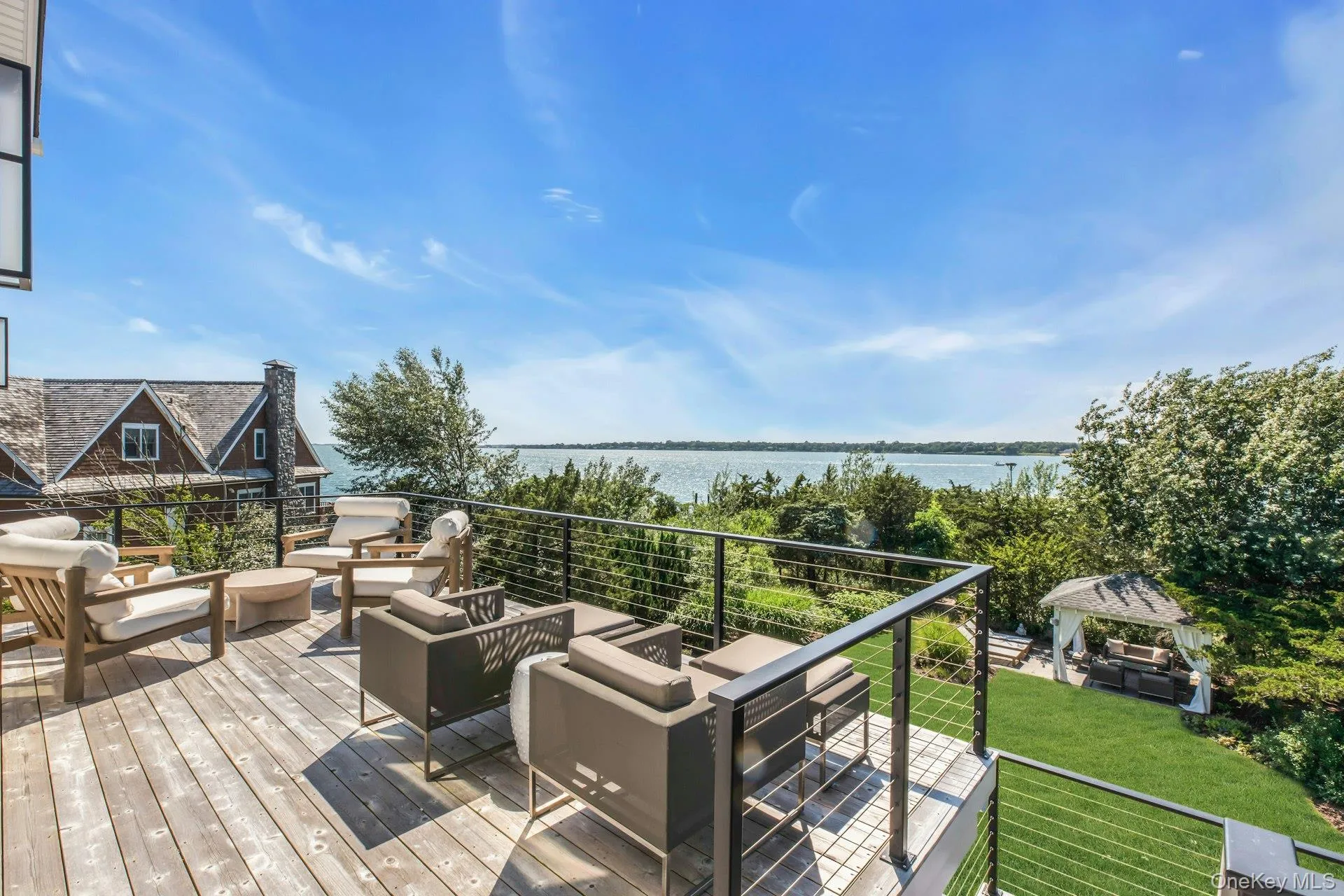 Spacious outdoor deck featuring wood-finish decking and a modern cable railing system Spacious outdoor deck featuring wood-finish decking and a modern cable railing system