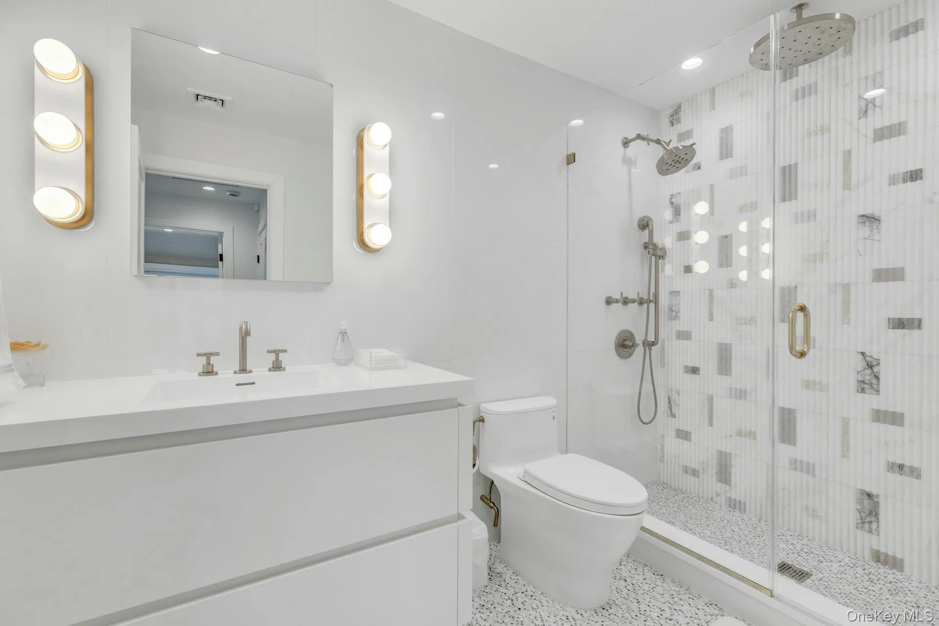 Modern bathroom featuring a glass-enclosed shower with dual shower heads, mosaic tile shower surround, and pebble-finish floor Modern bathroom featuring a glass-enclosed shower with dual shower heads, mosaic tile shower surround, and pebble-finish floor