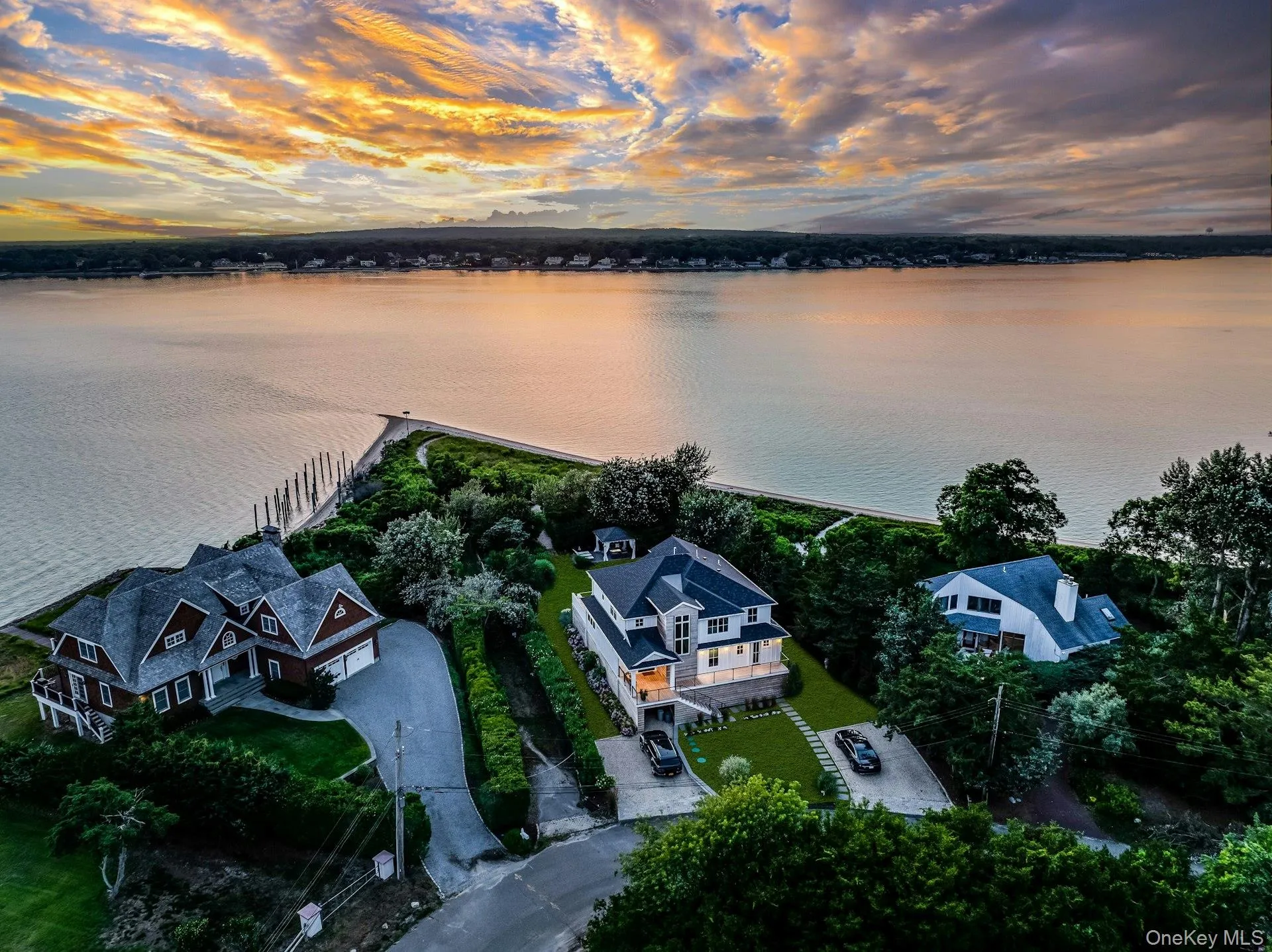 Waterfront property featuring extensive shoreline frontage, multiple residential structures, mature trees, and a private dock structure Waterfront property featuring extensive shoreline frontage, multiple residential structures, mature trees, and a private dock structure