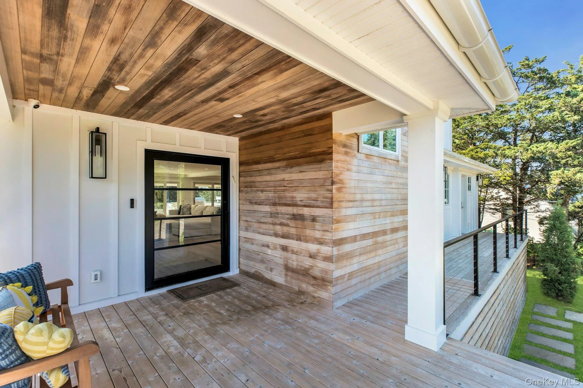 Covered porch featuring a wood-plank ceiling, wood-finish flooring, and white paneled walls Covered porch featuring a wood-plank ceiling, wood-finish flooring, and white paneled walls