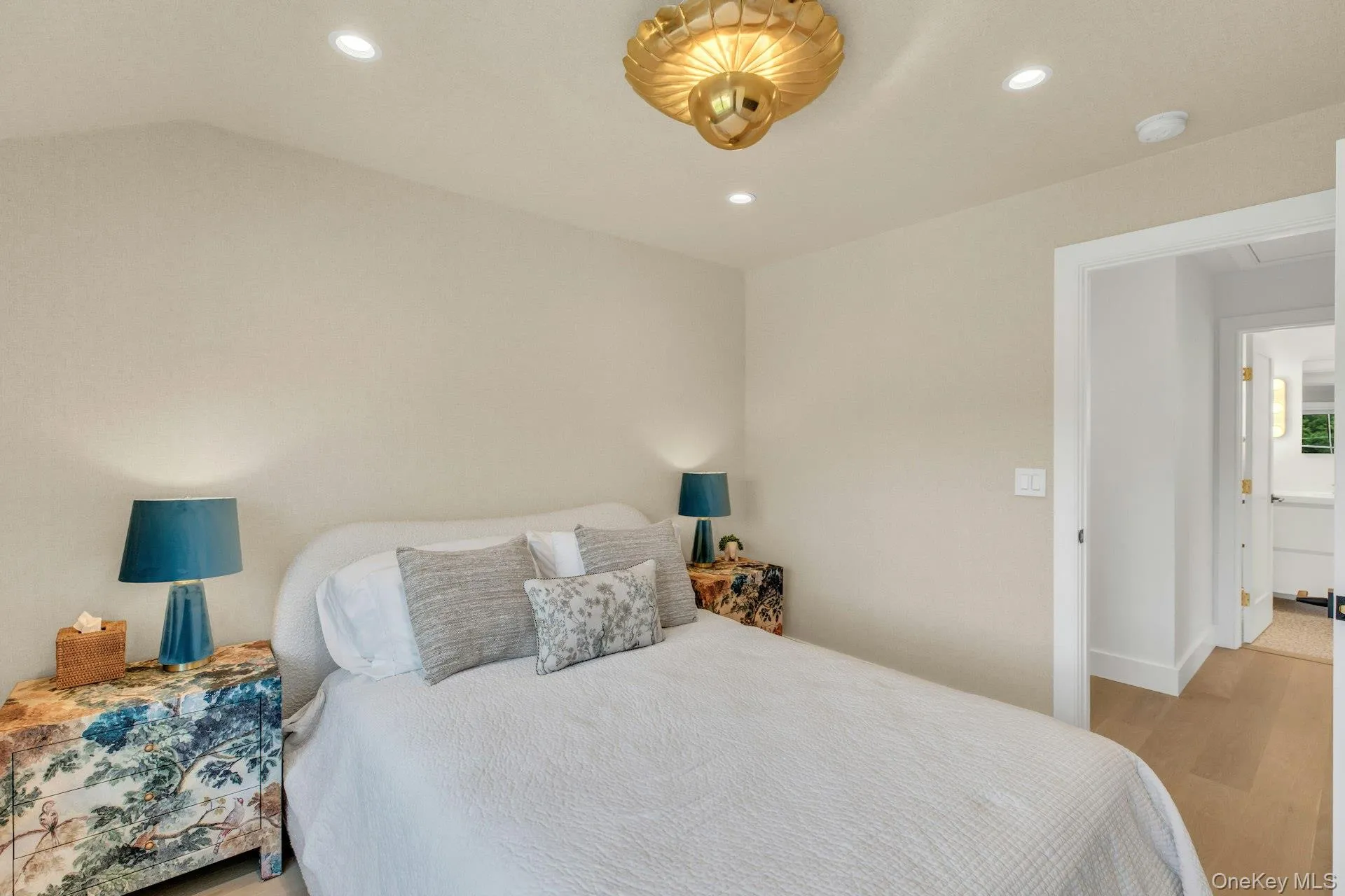 Bedroom featuring light-toned walls, recessed lighting, and a decorative ceiling fixture Bedroom featuring light-toned walls, recessed lighting, and a decorative ceiling fixture