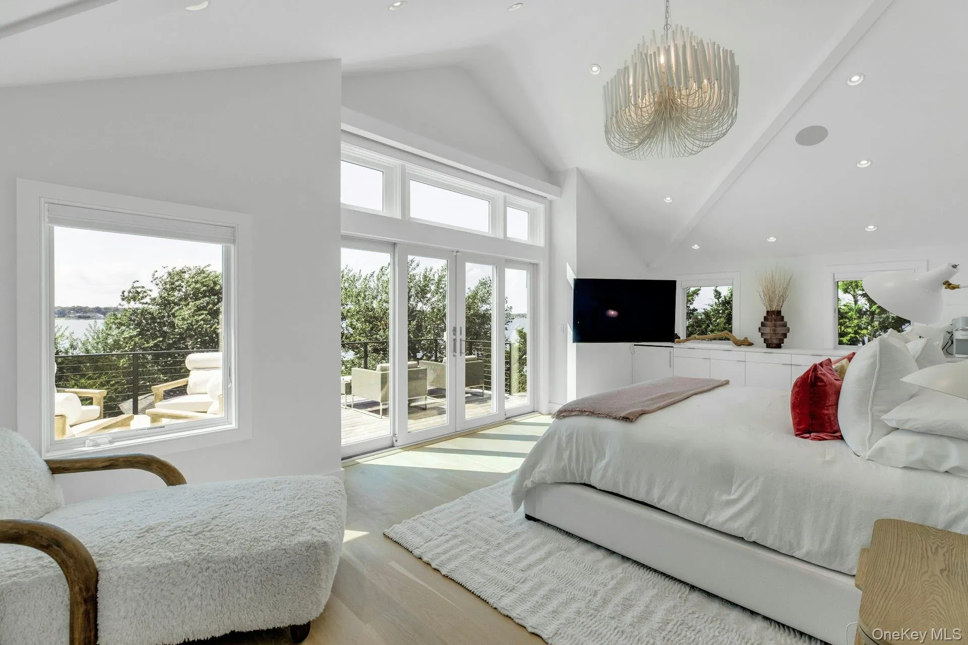 Spacious room featuring vaulted ceilings, a contemporary chandelier, recessed lighting, and light wood-finish flooring Spacious room featuring vaulted ceilings, a contemporary chandelier, recessed lighting, and light wood-finish flooring