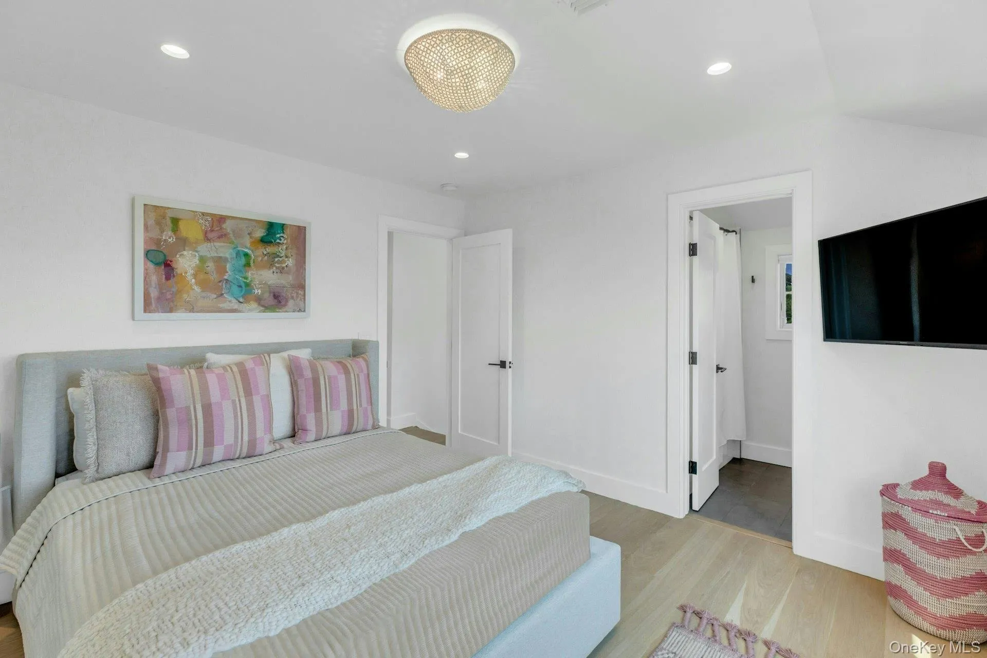 Guest Bedroom with Light wood-finish flooring complements white walls with recessed lighting and a central decorative fixture Guest Bedroom with Light wood-finish flooring complements white walls with recessed lighting and a central decorative fixture