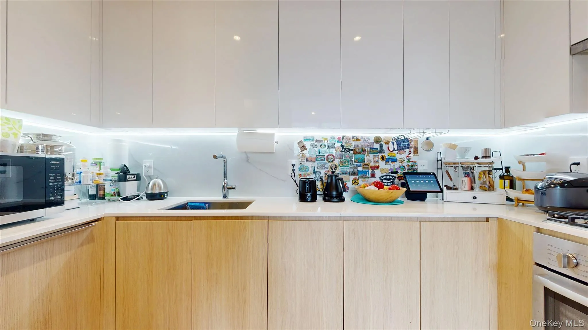 Kitchen featuring modern cabinets, a sink, light brown cabinetry, and oven Kitchen featuring modern cabinets, a sink, light brown cabinetry, and oven