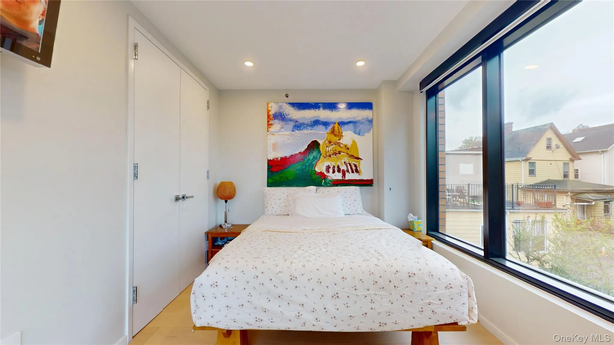 Bedroom with multiple windows, light wood-style flooring, recessed lighting, baseboards, and a closet Bedroom with multiple windows, light wood-style flooring, recessed lighting, baseboards, and a closet