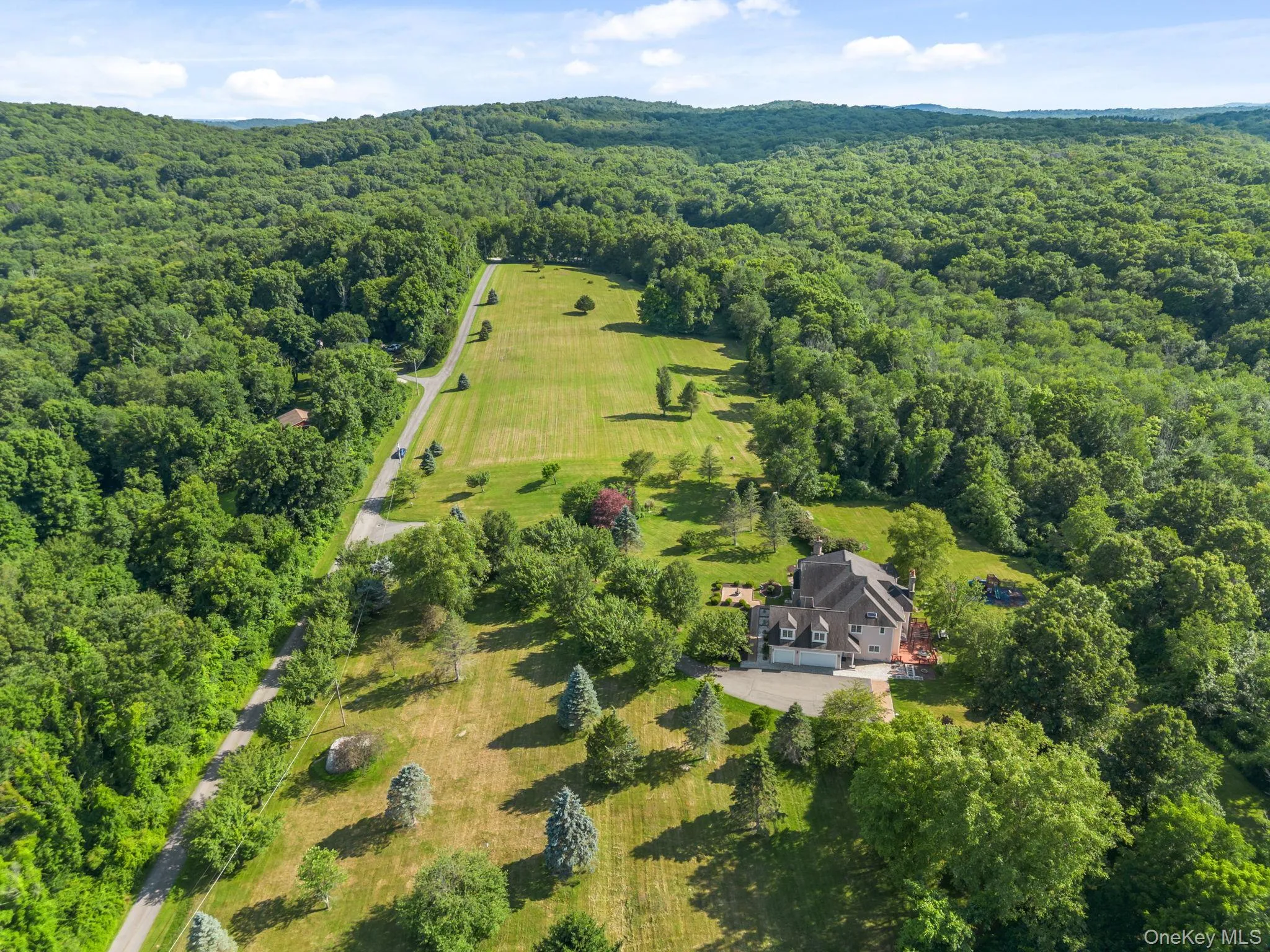 A breathtaking aerial perspective reveals the property’s pristine acreage, beautifully maintained landscaping, open level lawns, and mature wooded areas. A breathtaking aerial perspective reveals the property’s pristine acreage, beautifully maintained landscaping, open level lawns, and mature wooded areas.