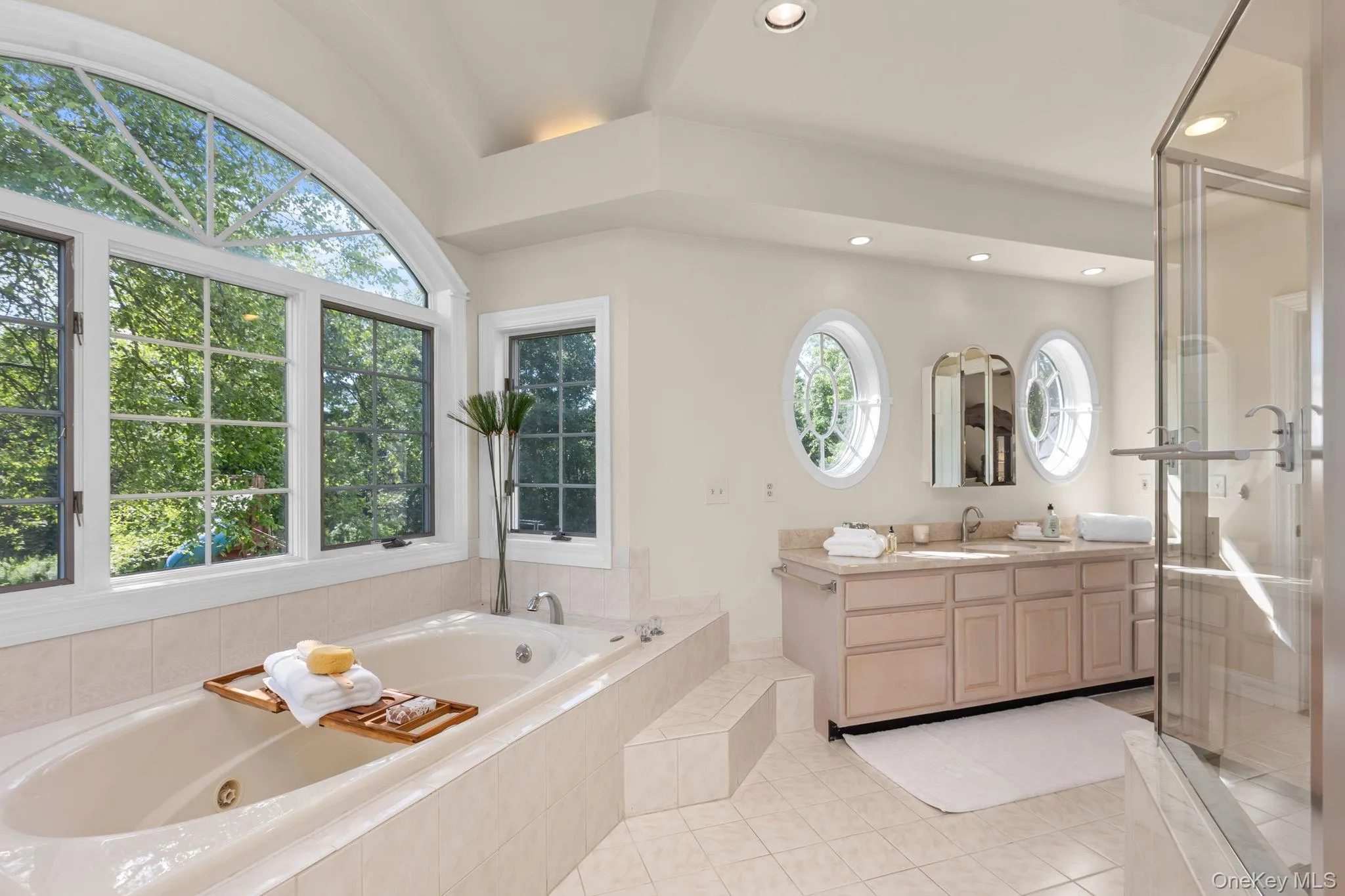 Designed for relaxation, this sophisticated bathroom features two vanities and a tranquil soaking tub. Designed for relaxation, this sophisticated bathroom features two vanities and a tranquil soaking tub.