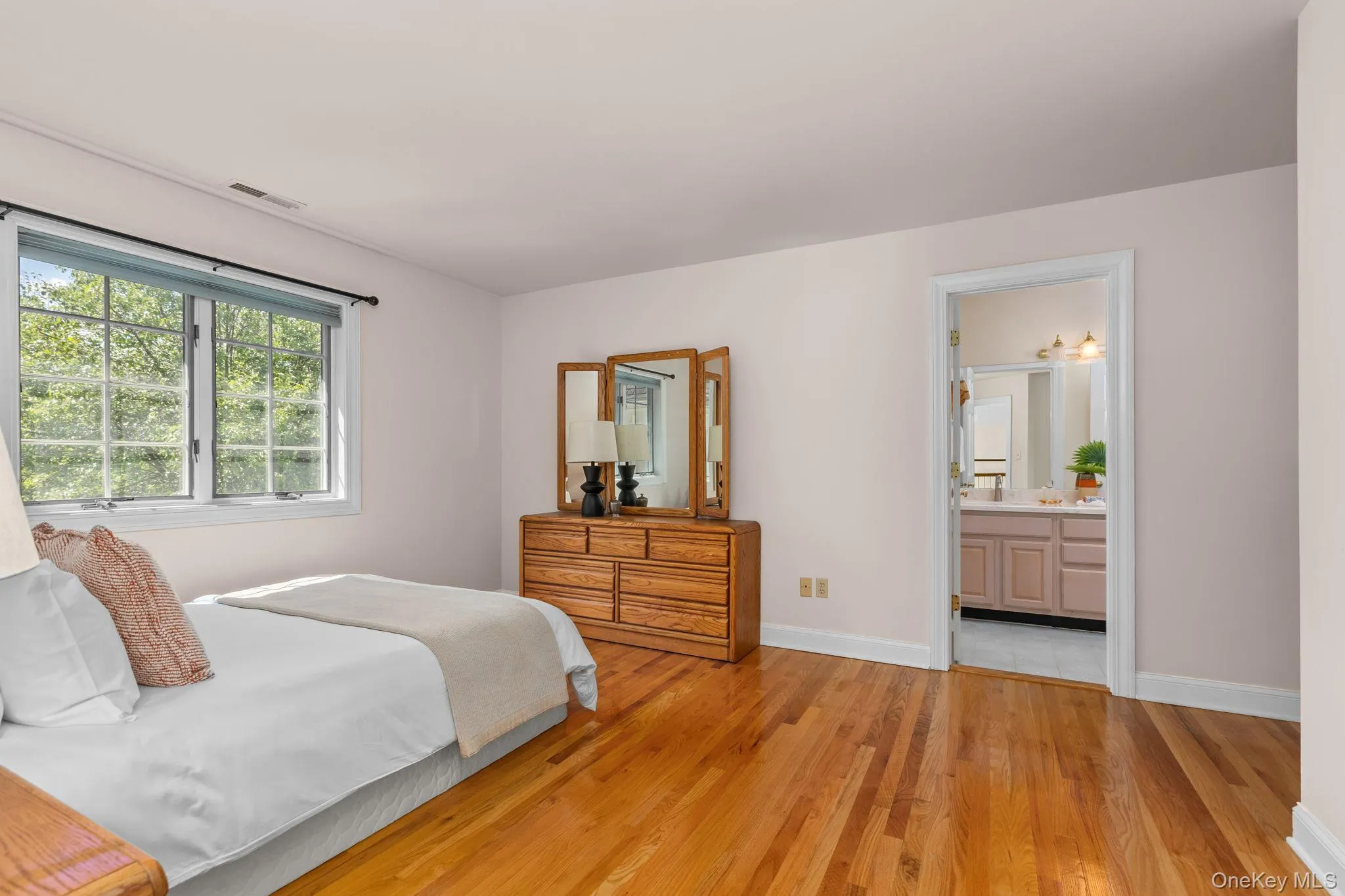 Bright and inviting bedroom with peaceful backyard views, hardwood floors, and convenient access to a shared bath. Bright and inviting bedroom with peaceful backyard views, hardwood floors, and convenient access to a shared bath.