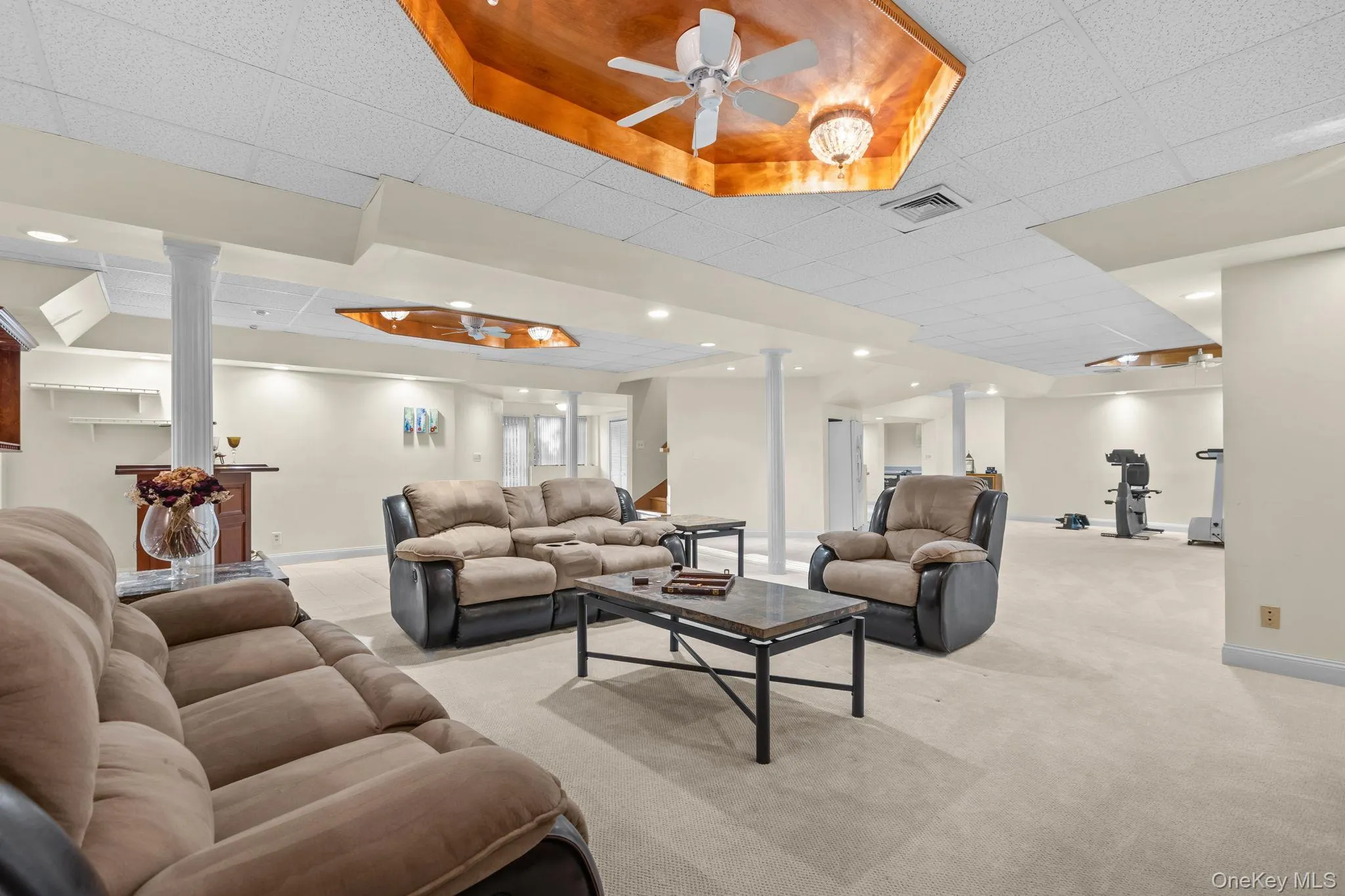 Thoughtfully designed, this recreation space features a dedicated exercise alcove, ceiling fans, and a beautifully crafted ceiling detail. Thoughtfully designed, this recreation space features a dedicated exercise alcove, ceiling fans, and a beautifully crafted ceiling detail.