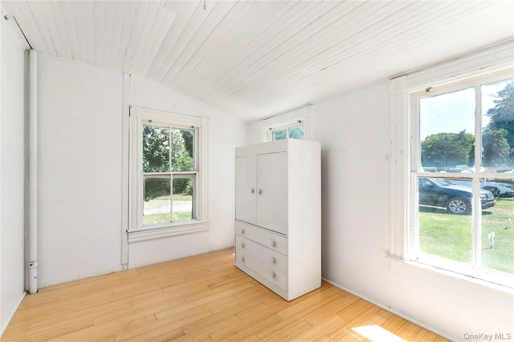 Unfurnished bedroom with vaulted ceiling and light wood-type flooring Unfurnished bedroom with vaulted ceiling and light wood-type flooring