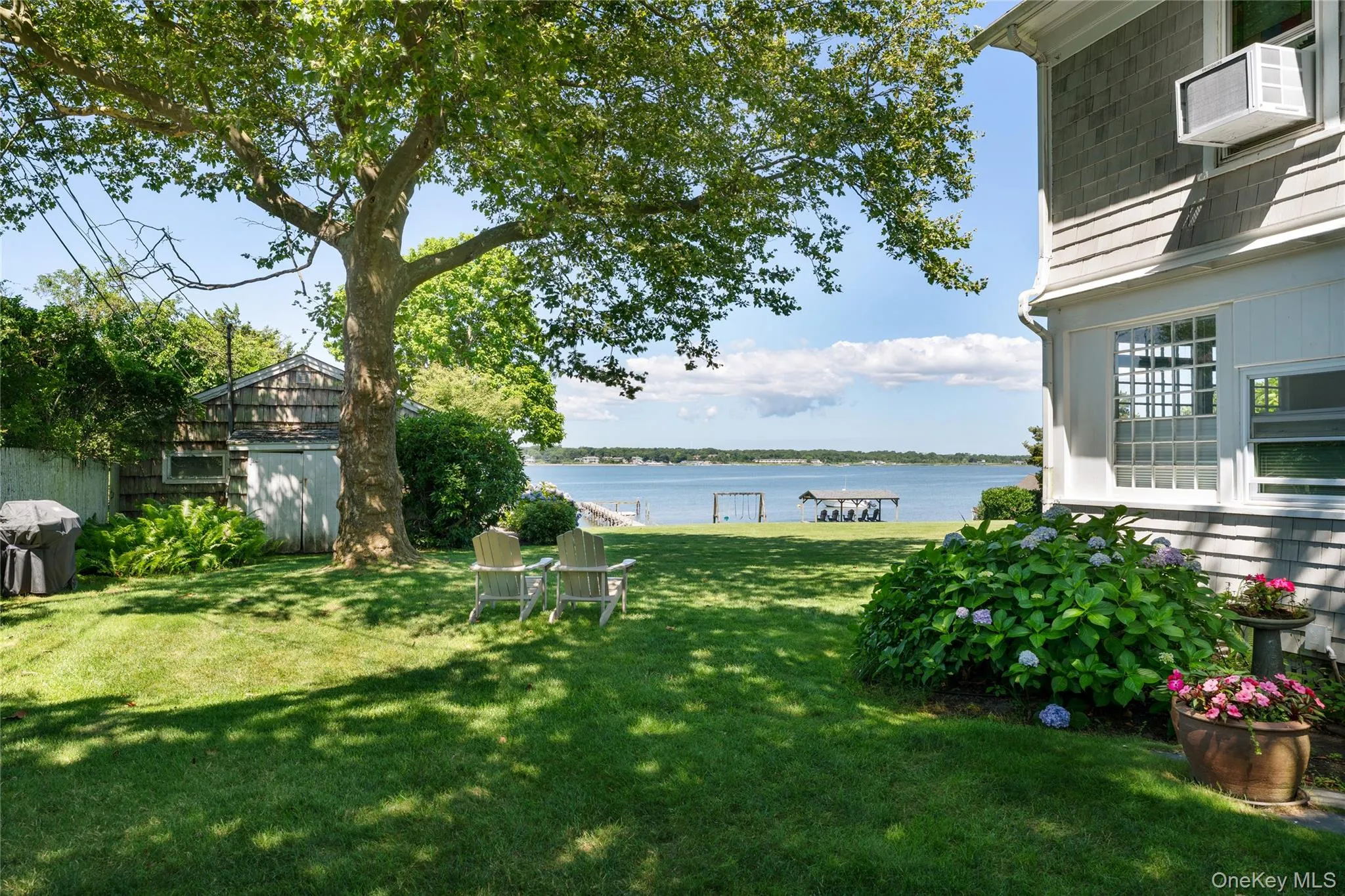View of green lawn with a water view and an outbuilding View of green lawn with a water view and an outbuilding
