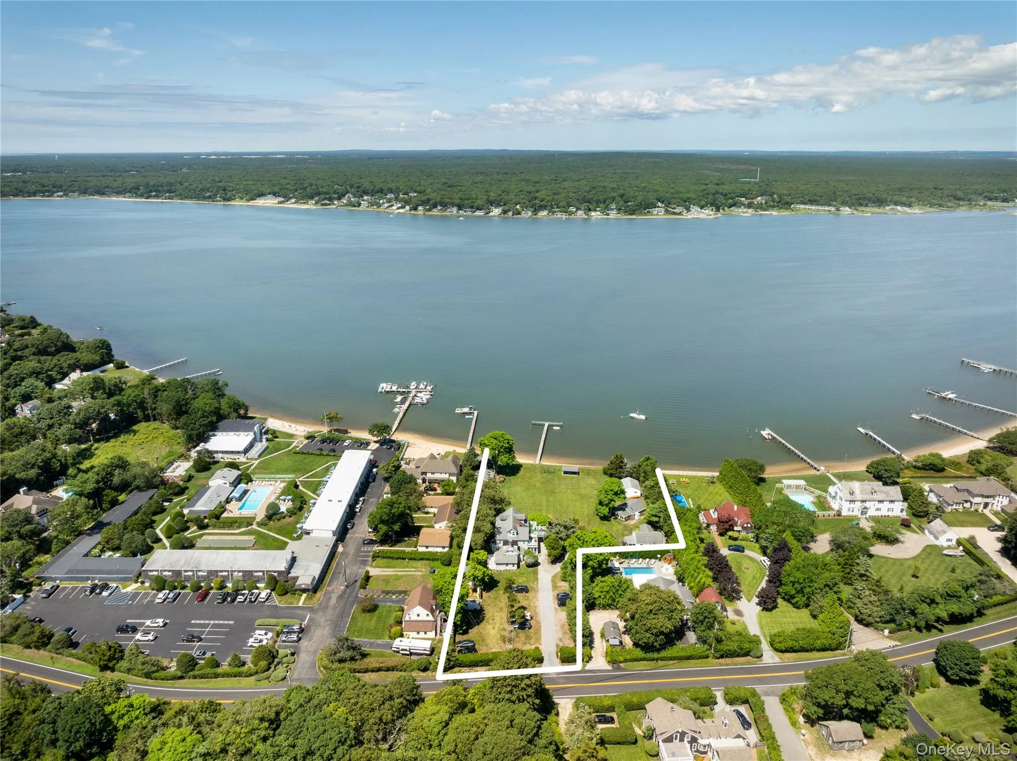 Aerial view of property and surrounding area with a large body of water and property boundaries highlighted Aerial view of property and surrounding area with a large body of water and property boundaries highlighted