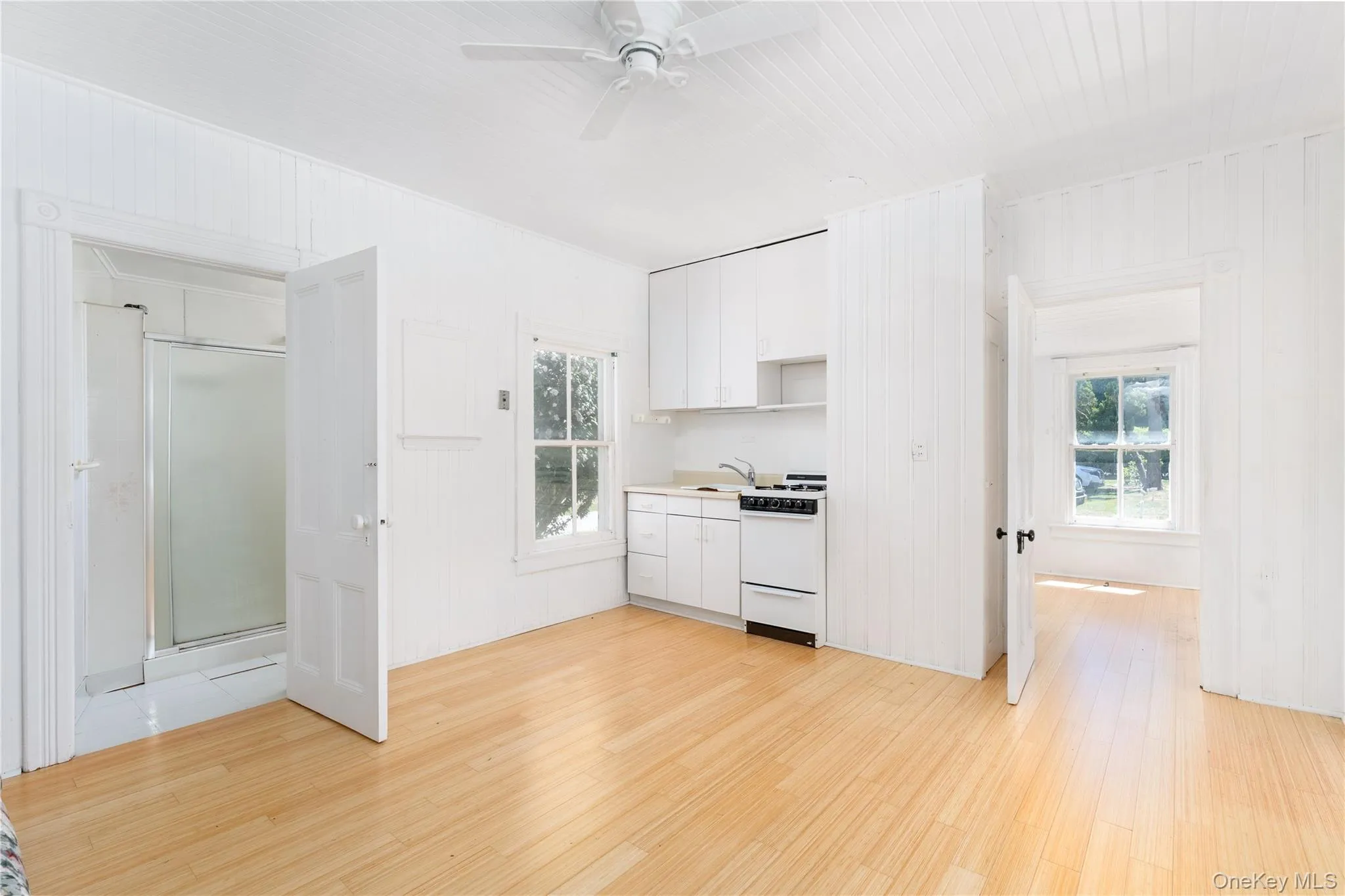 Kitchen featuring light wood-style floors, white cabinets, and white range with gas stovetop Kitchen featuring light wood-style floors, white cabinets, and white range with gas stovetop