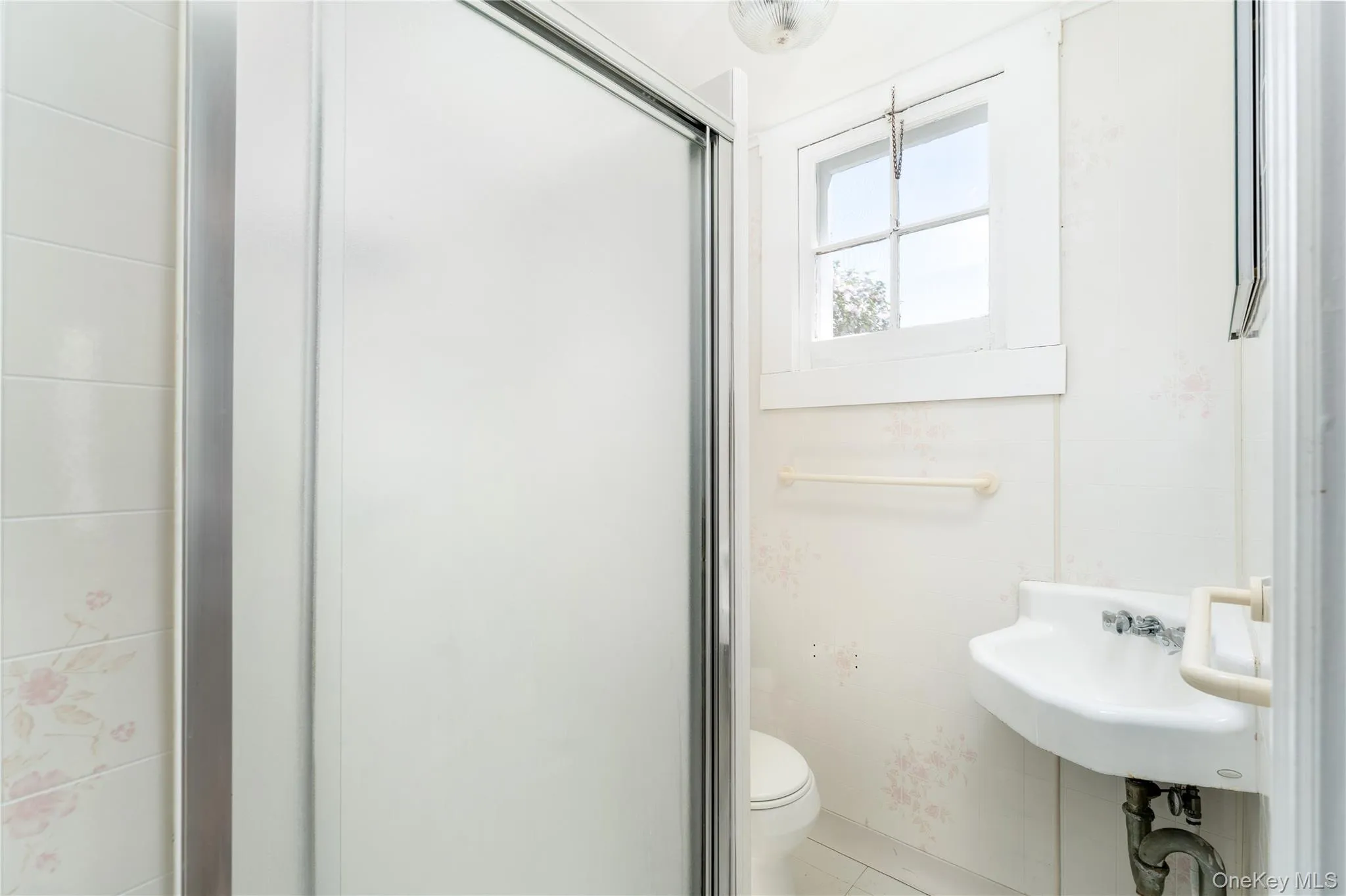 Bathroom with a stall shower and tile patterned flooring Bathroom with a stall shower and tile patterned flooring