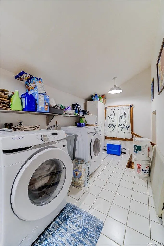 Dedicated utility area featuring white square tile flooring and a built-in shelf Dedicated utility area featuring white square tile flooring and a built-in shelf