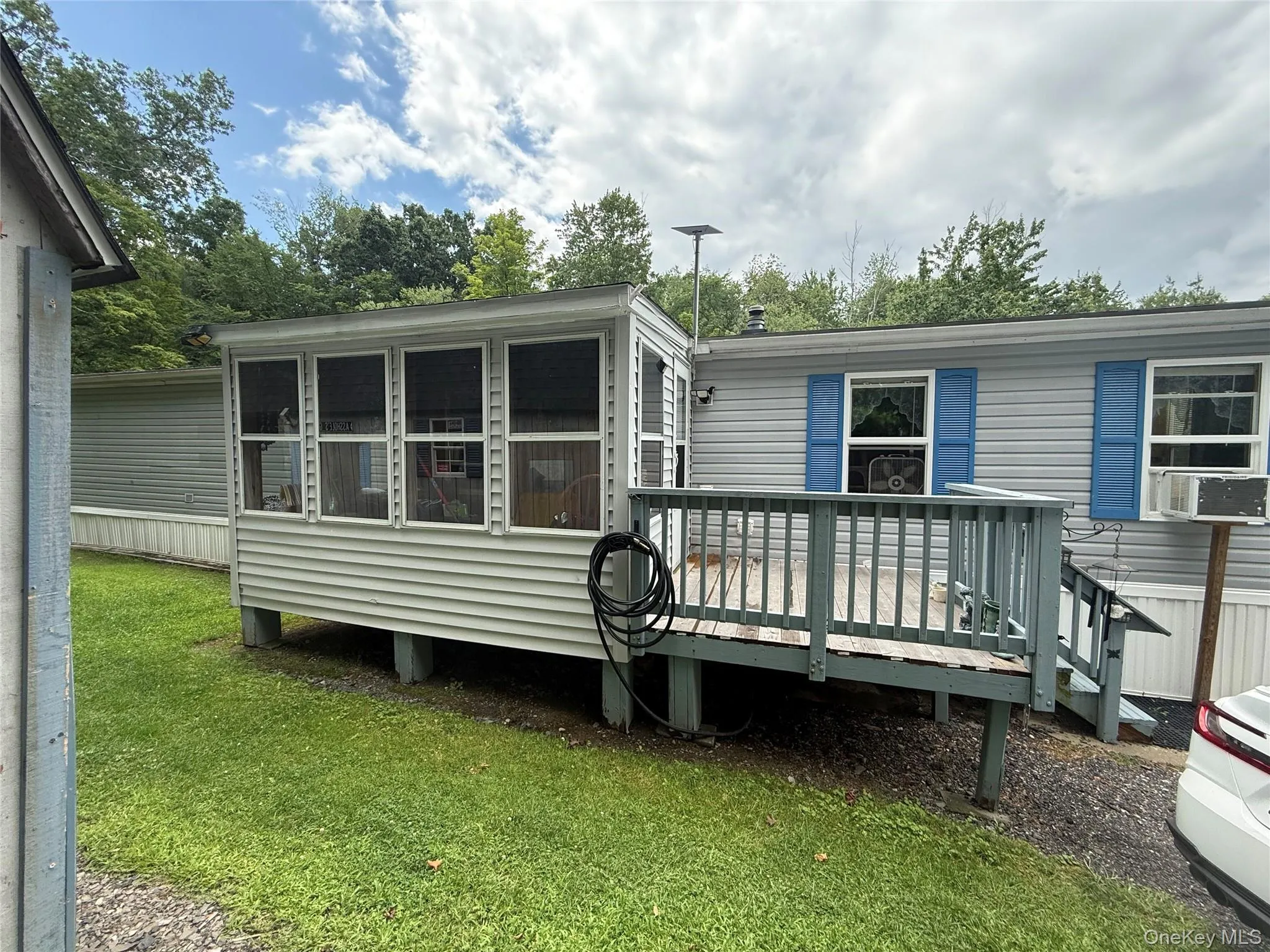 Side of home with enclosed sun room. Side of home with enclosed sun room.