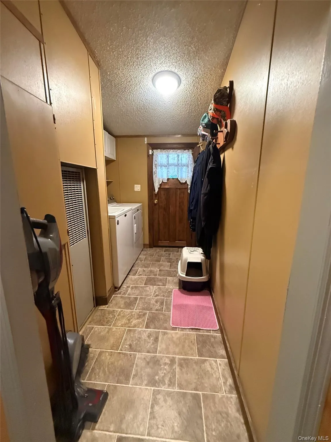 Hallway with washer and dryer, oil furnace, electric box leading to enclosed porch. Hallway with washer and dryer, oil furnace, electric box leading to enclosed porch.