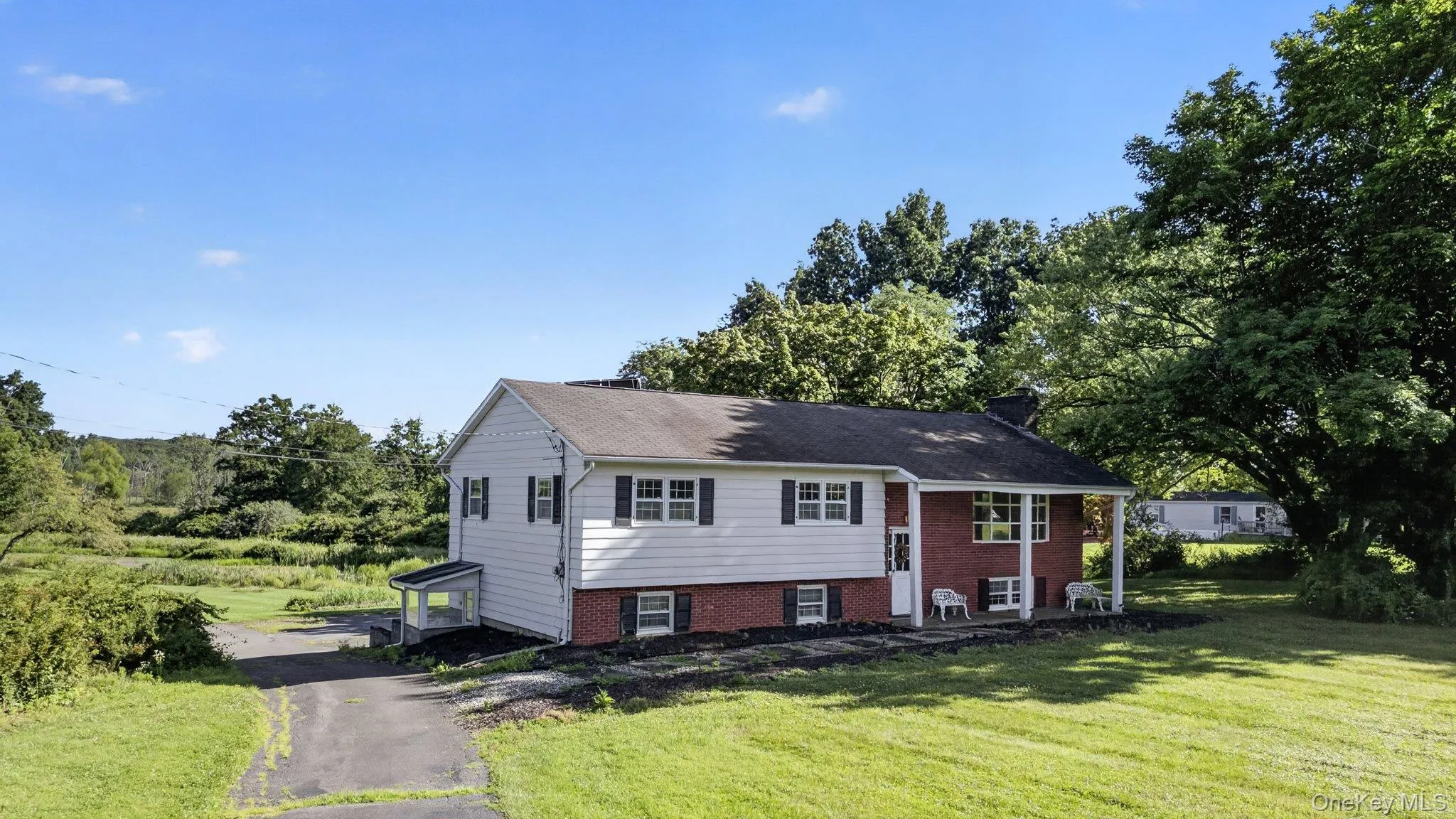 Split-level residence featuring a white siding upper level and a red brick lower level Split-level residence featuring a white siding upper level and a red brick lower level