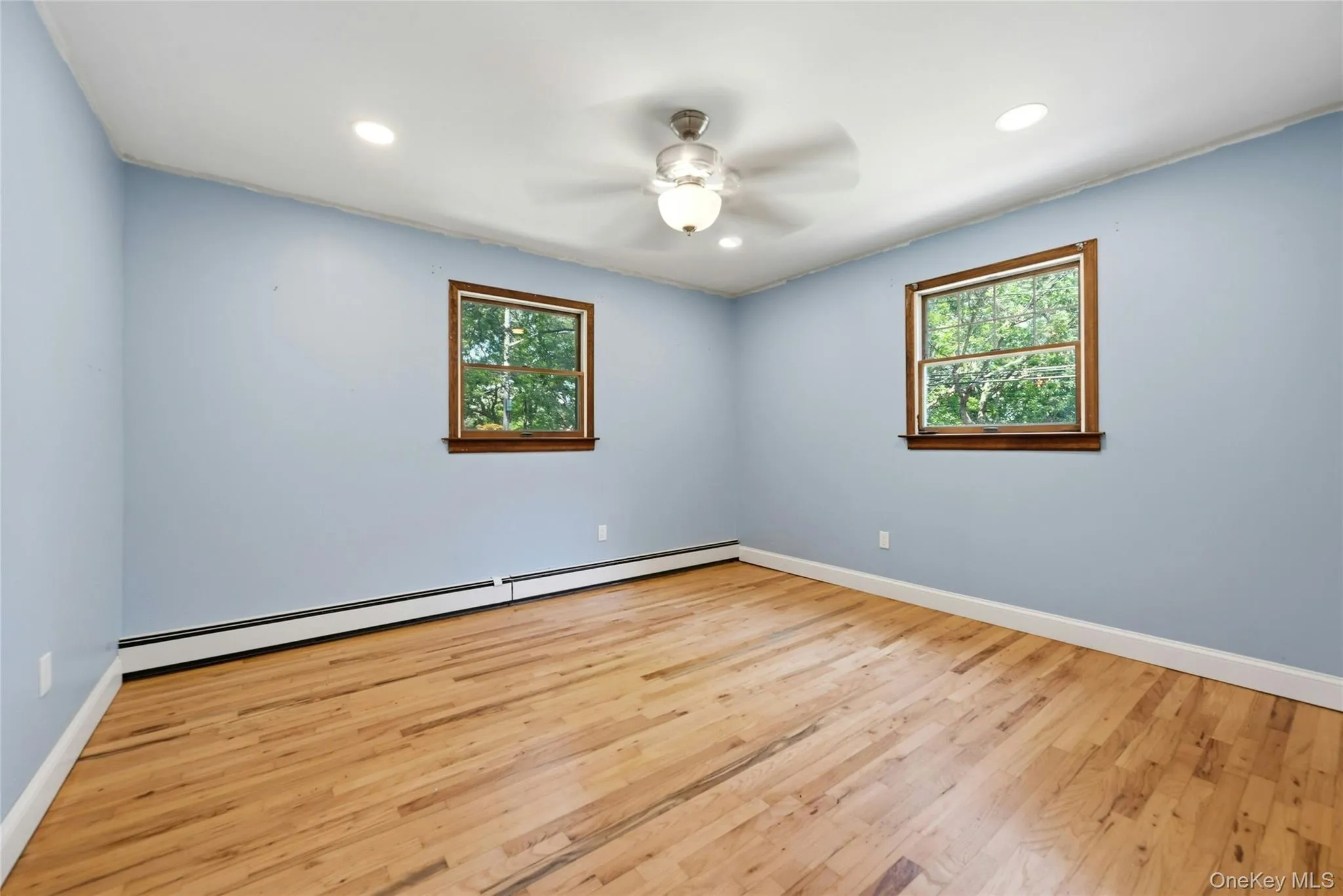 Spacious Sunlit Primary Bedroom w/ Hardwood Flooring Spacious Sunlit Primary Bedroom w/ Hardwood Flooring
