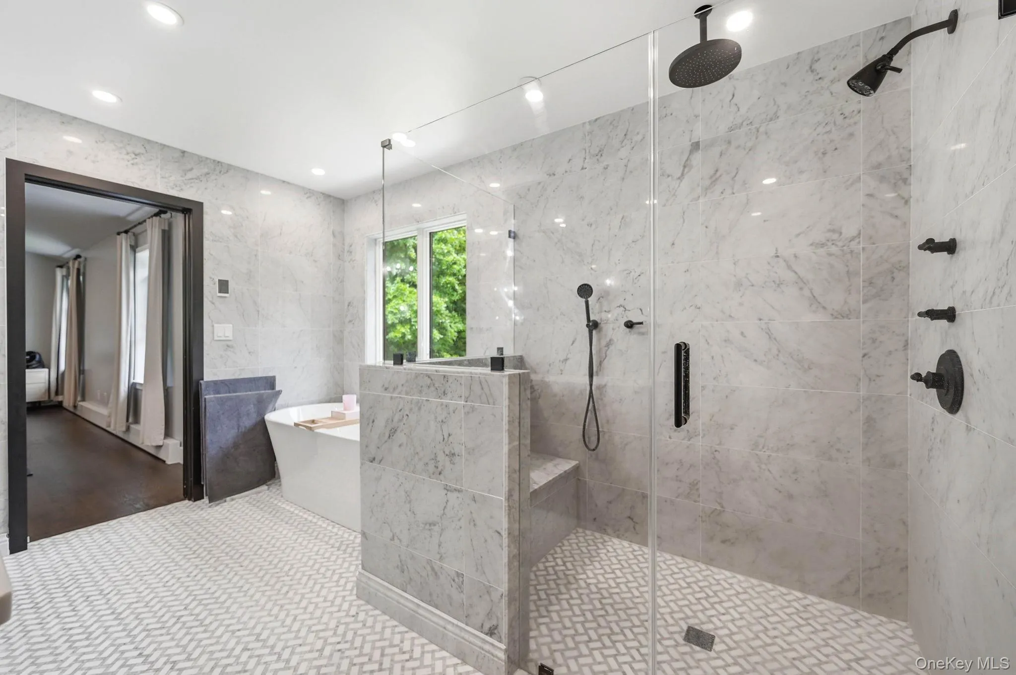 Spacious bathroom featuring a frameless glass shower enclosure, matte black fixtures, and a built-in shower bench Spacious bathroom featuring a frameless glass shower enclosure, matte black fixtures, and a built-in shower bench