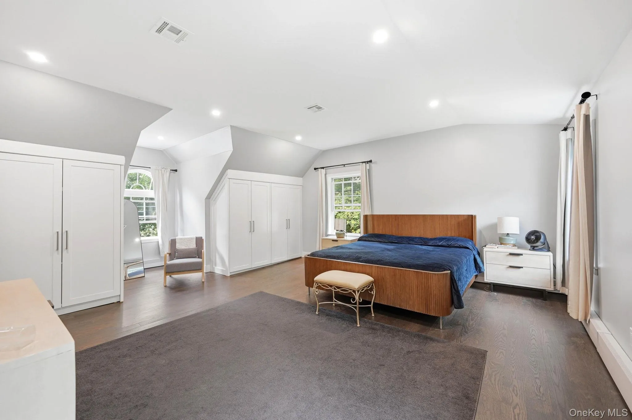 Spacious room featuring wood-finish flooring, recessed lighting, and multiple built-in storage units Spacious room featuring wood-finish flooring, recessed lighting, and multiple built-in storage units