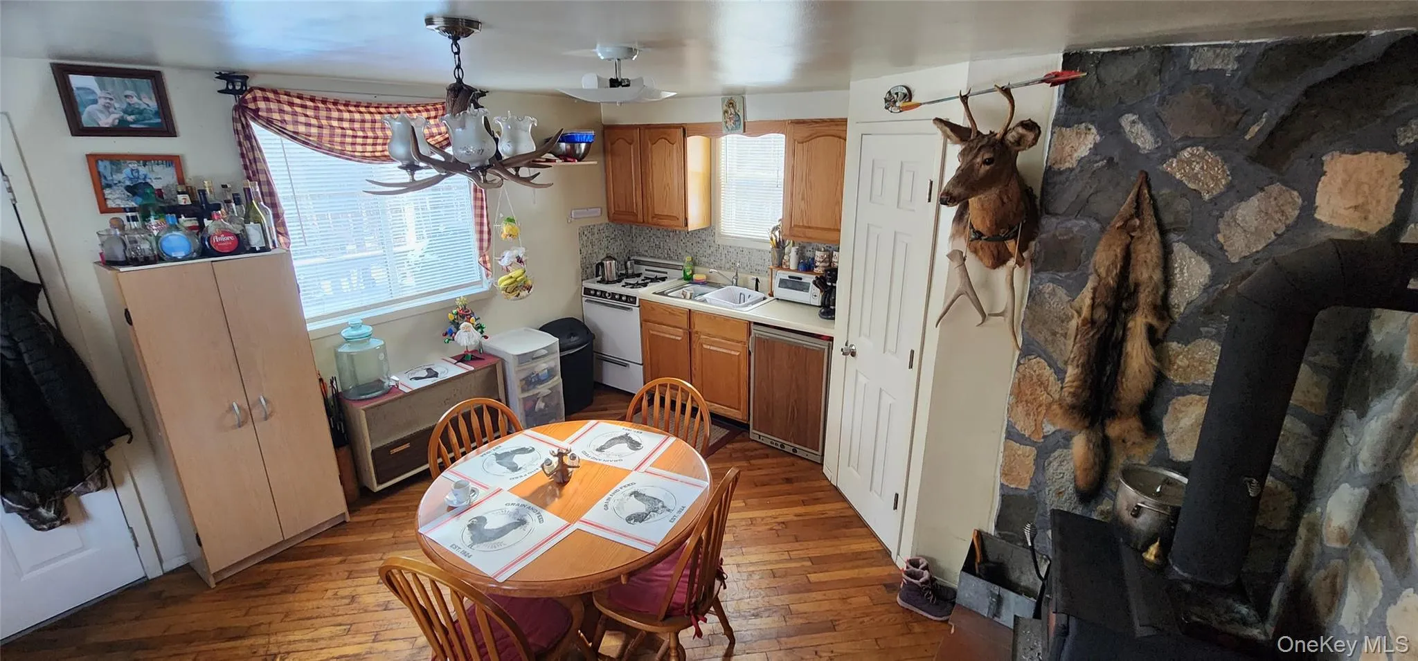 Kitchen featuring decorative backsplash, light hardwood / wood-style flooring, dishwashing machine, and a notable chandelier Kitchen featuring decorative backsplash, light hardwood / wood-style flooring, dishwashing machine, and a notable chandelier