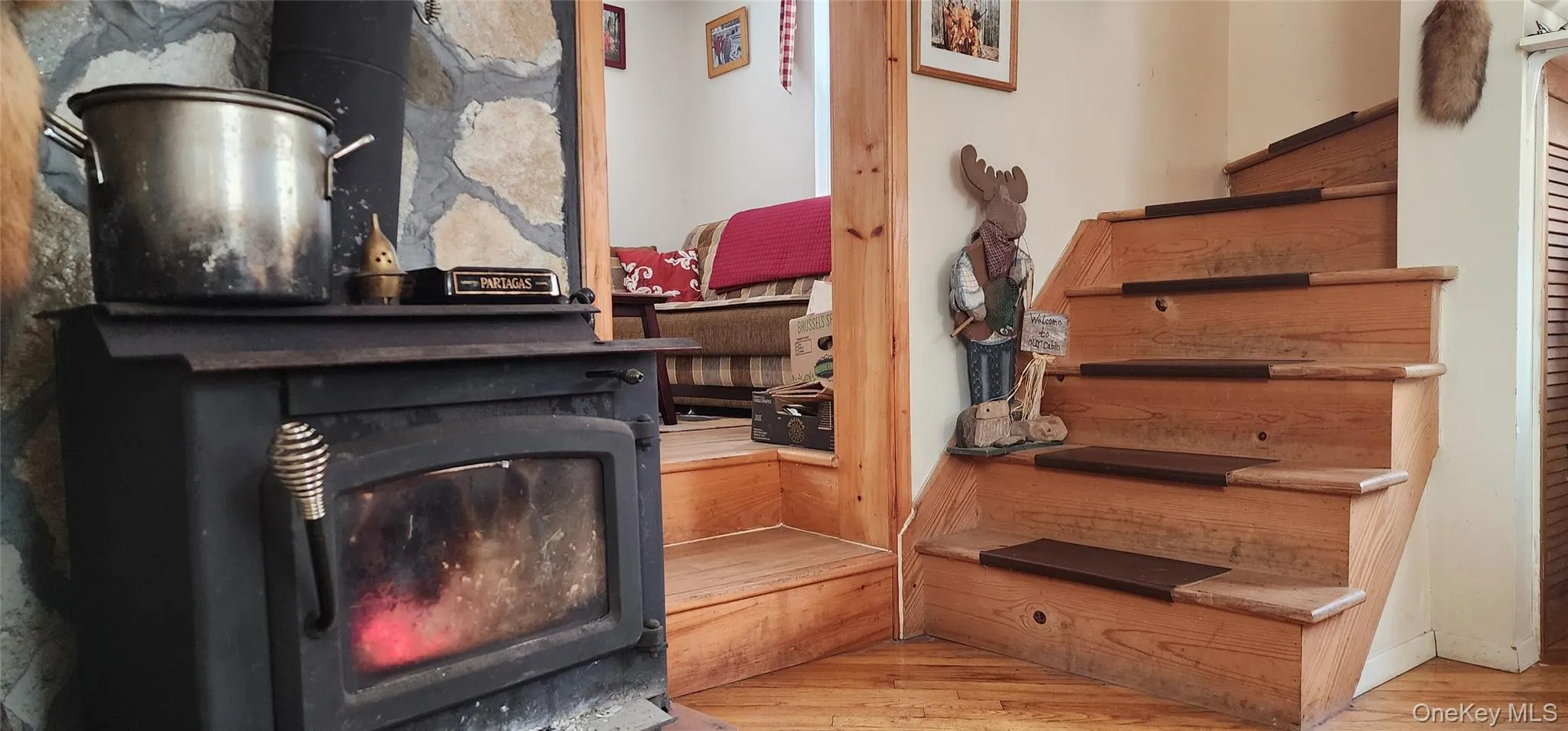 Stairs featuring hardwood / wood-style flooring and a wood stove Stairs featuring hardwood / wood-style flooring and a wood stove