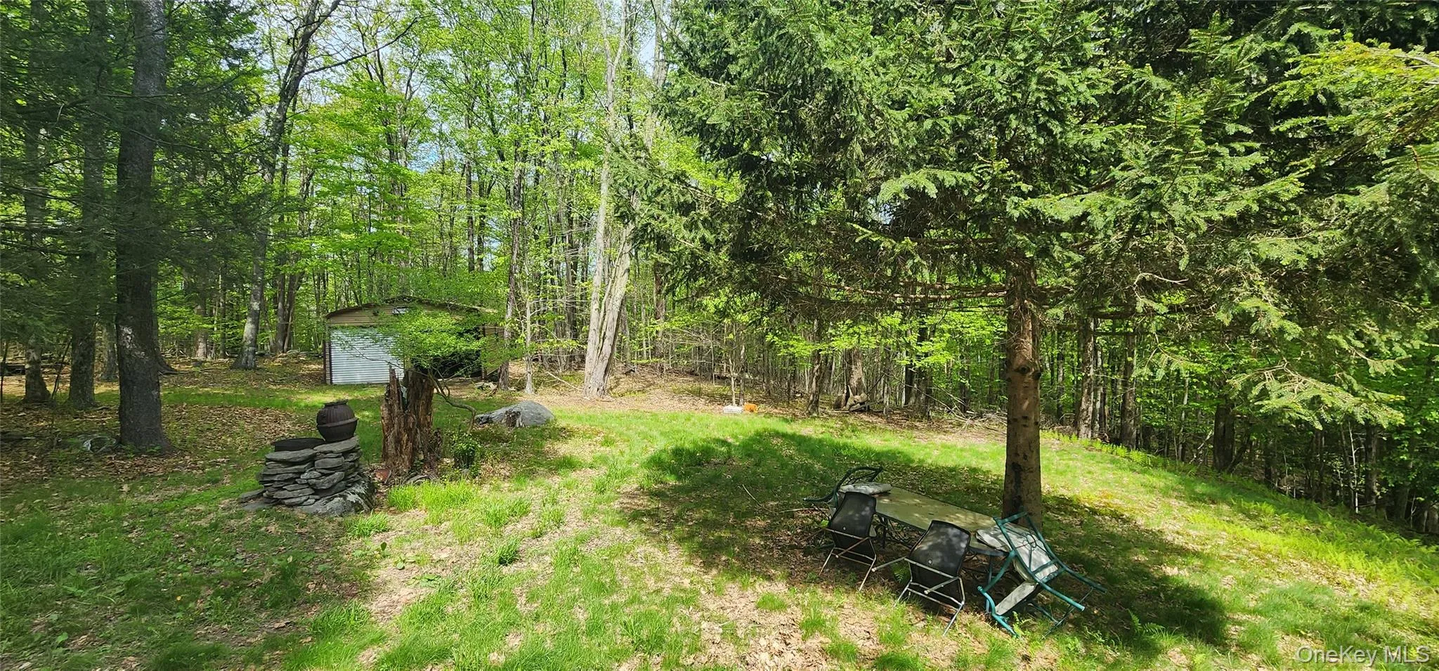View of yard with an outdoor structure, a storage shed, and a wooded view View of yard with an outdoor structure, a storage shed, and a wooded view
