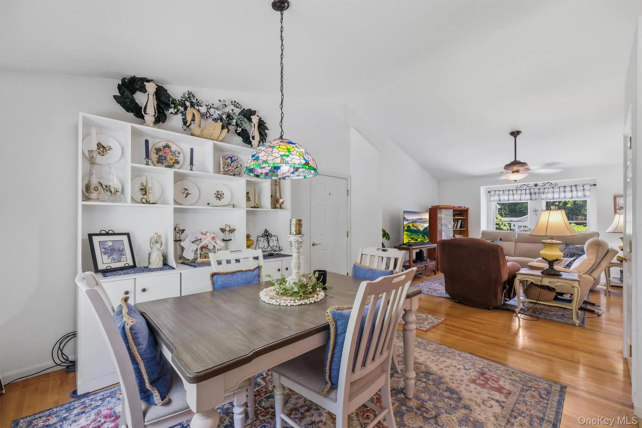 Built-in display shelving, vaulted ceilings, a decorative pendant light, and polished wood-finish flooring Built-in display shelving, vaulted ceilings, a decorative pendant light, and polished wood-finish flooring