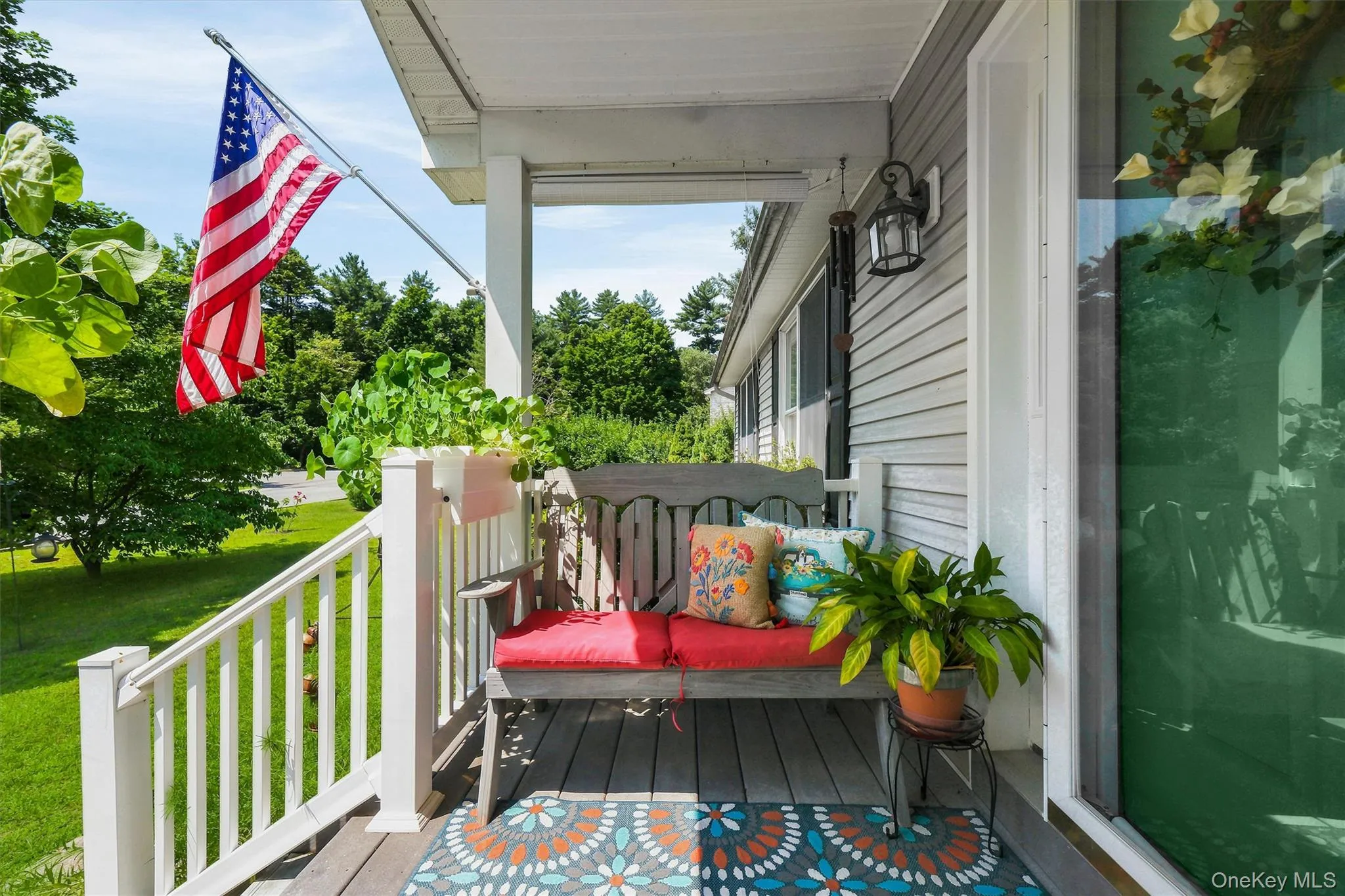 Covered front porch featuring a wood-finish floor and white balustrade Covered front porch featuring a wood-finish floor and white balustrade