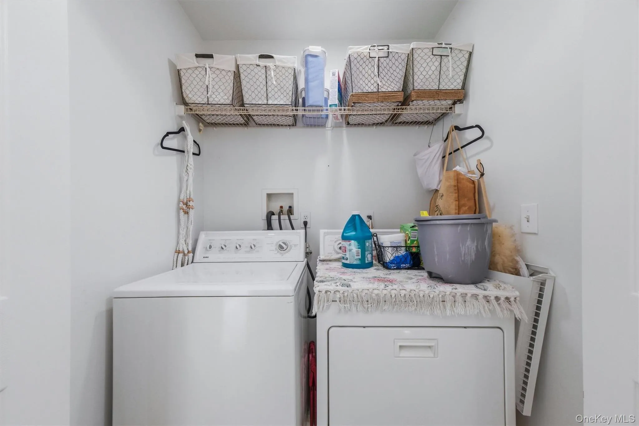 Dedicated laundry area with upper wire shelving Dedicated laundry area with upper wire shelving