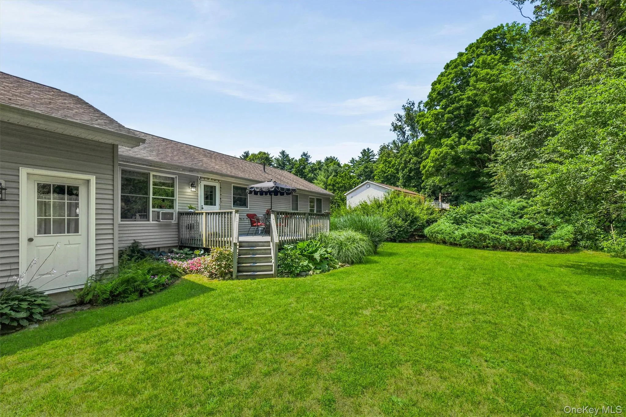 Expansive green lawn, multi-level wooden deck, and mature landscaping Expansive green lawn, multi-level wooden deck, and mature landscaping