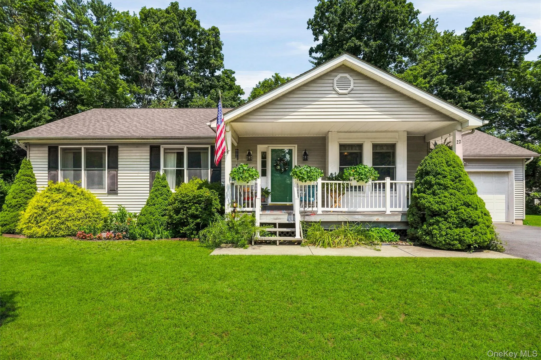 Siding exterior with a covered front porch, white railing, and a gabled roofline Siding exterior with a covered front porch, white railing, and a gabled roofline