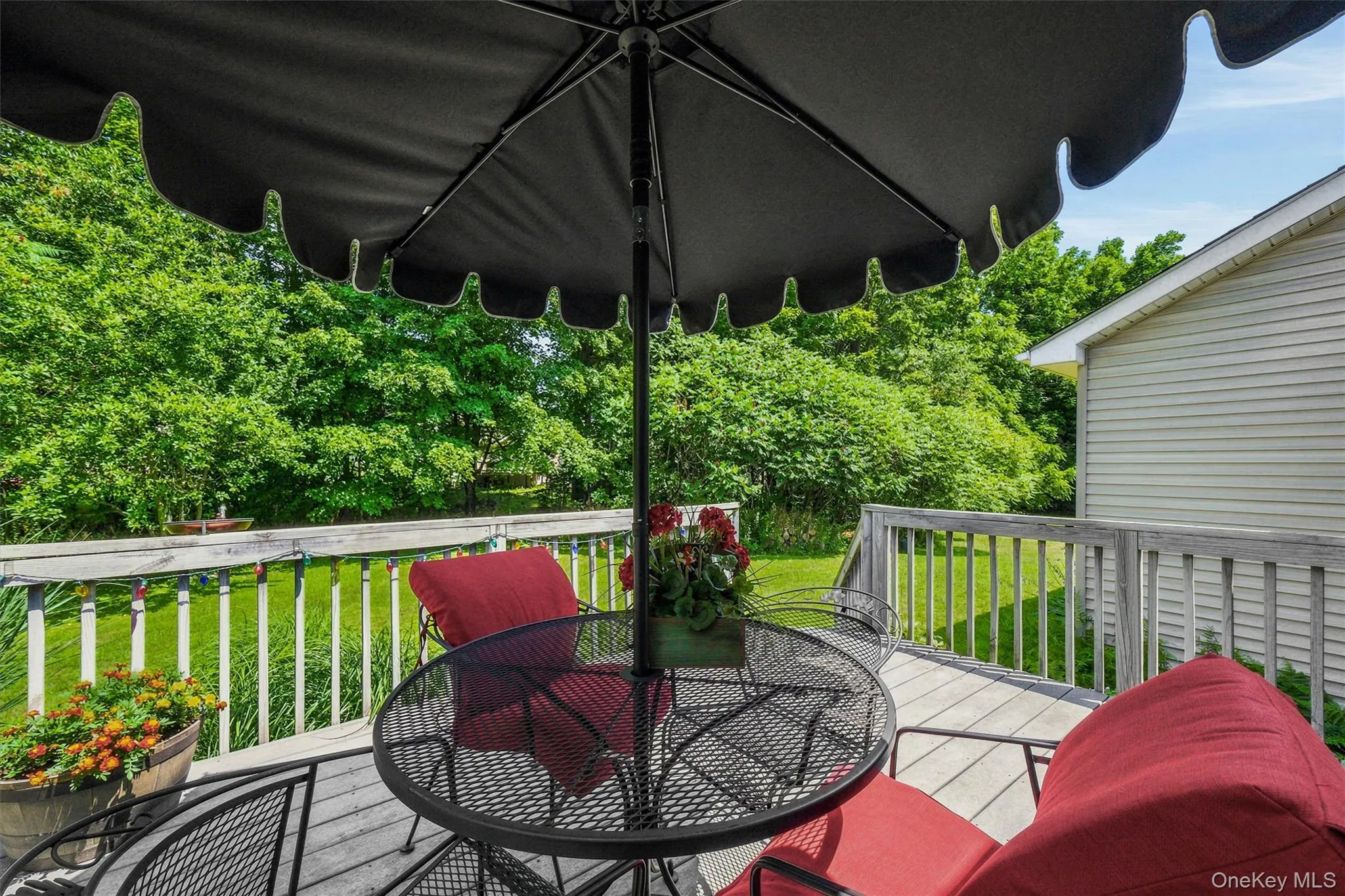 Spacious outdoor deck with a wood railing and balusters, overlooking a manicured lawn Spacious outdoor deck with a wood railing and balusters, overlooking a manicured lawn