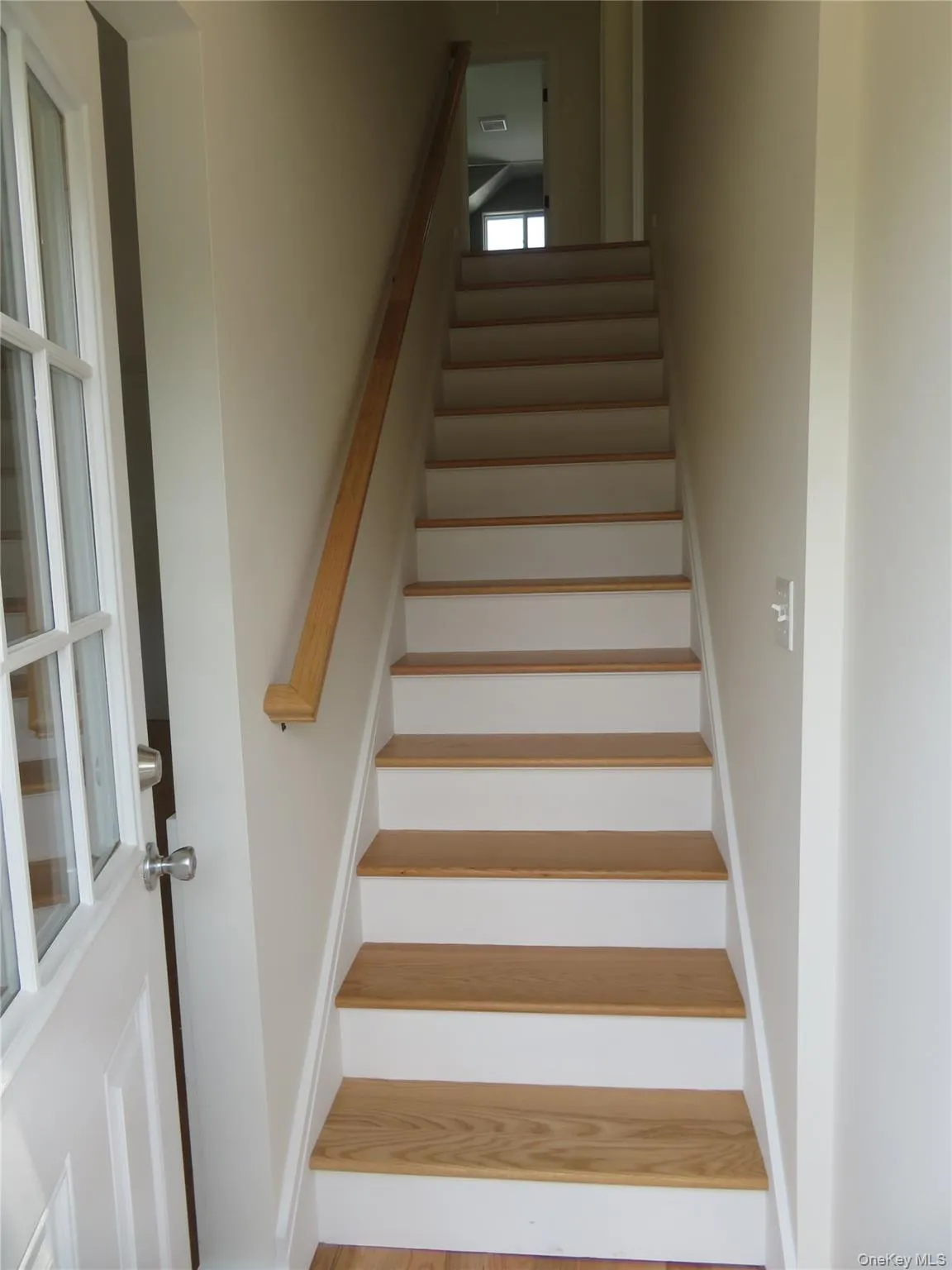 Hardwood stairs Up, with white risers and a natural wood handrail Hardwood stairs Up, with white risers and a natural wood handrail