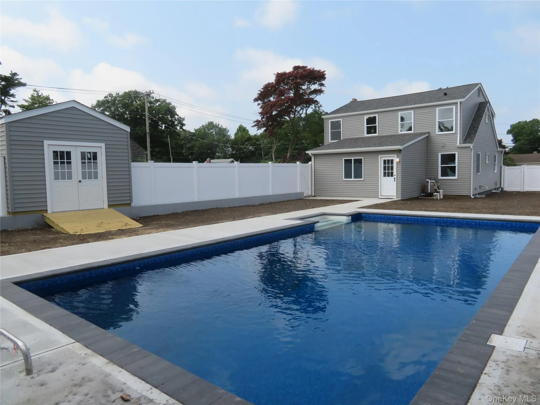 Rectangular inground swimming pool featuring a patterned liner and dark coping Rectangular inground swimming pool featuring a patterned liner and dark coping