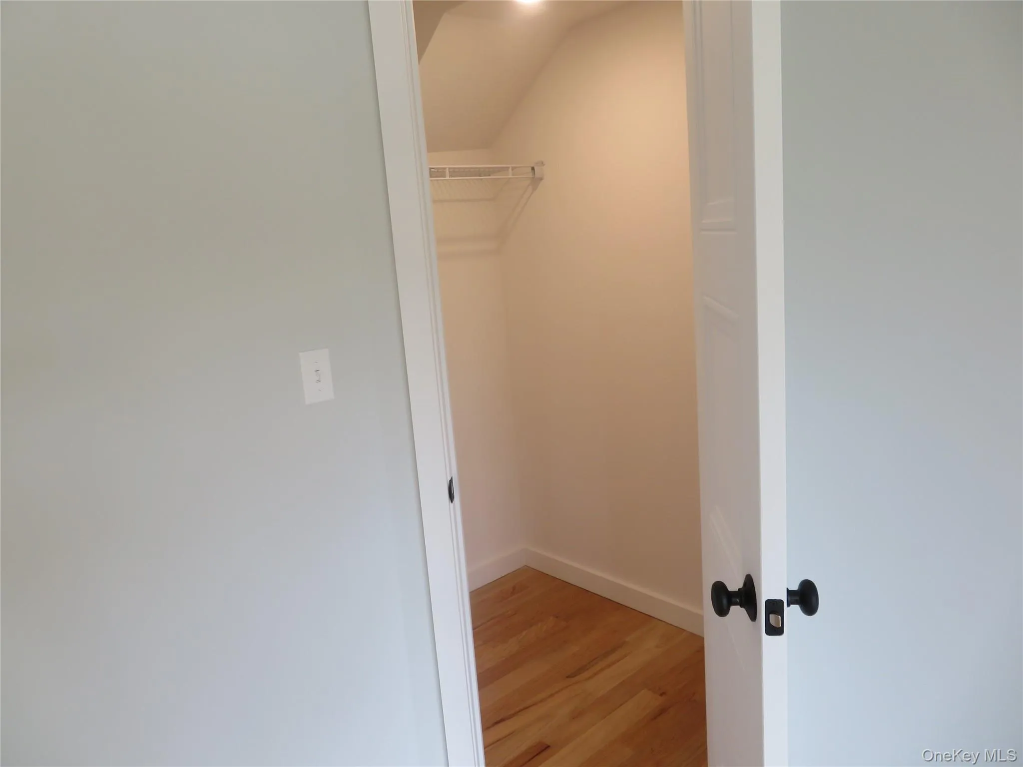 Interior closet with wood-finish flooring and a wire shelving system Interior closet with wood-finish flooring and a wire shelving system
