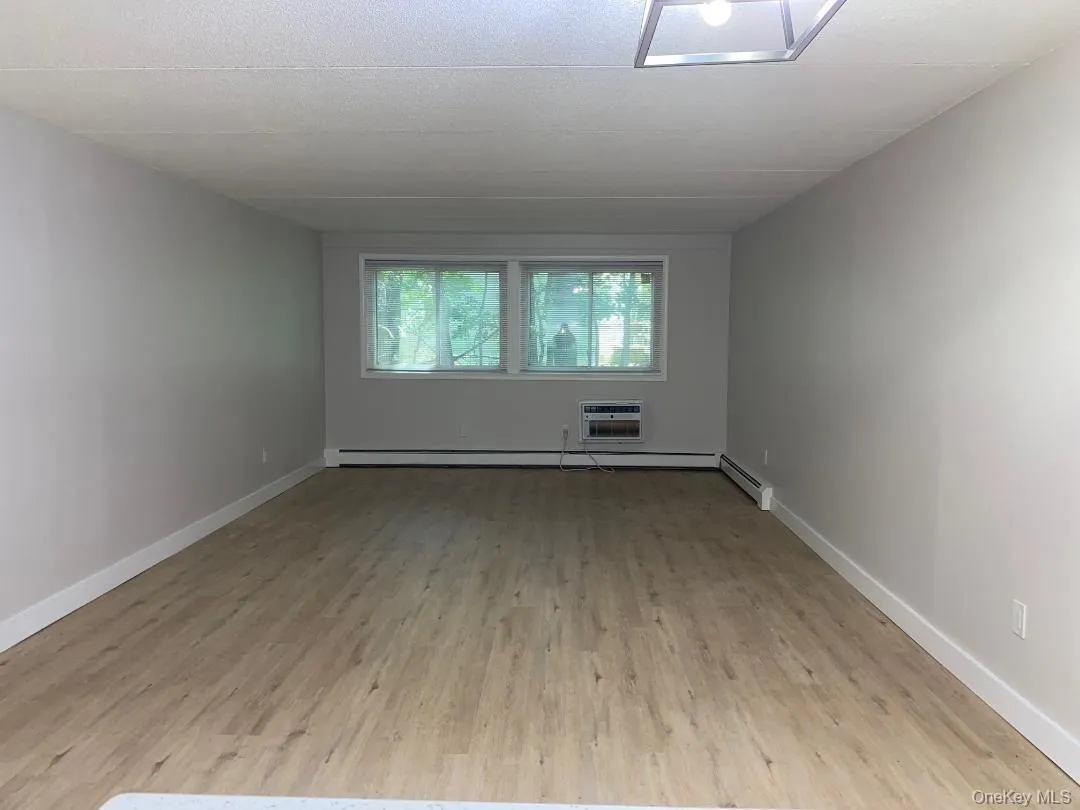 Spacious open living and dining room featuring wood-like flooring Spacious open living and dining room featuring wood-like flooring