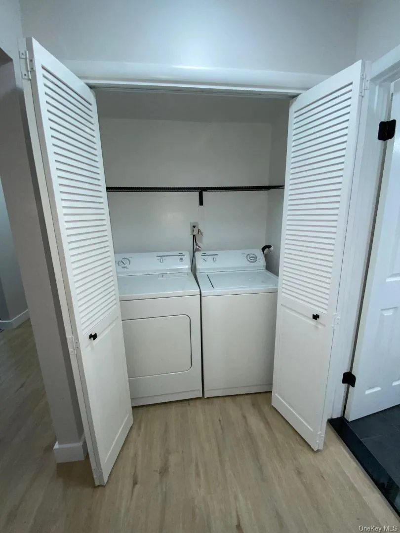 Private laundry area within the apartment featuring shelving storage area dn bi-fold louvered doors Private laundry area within the apartment featuring shelving storage area dn bi-fold louvered doors