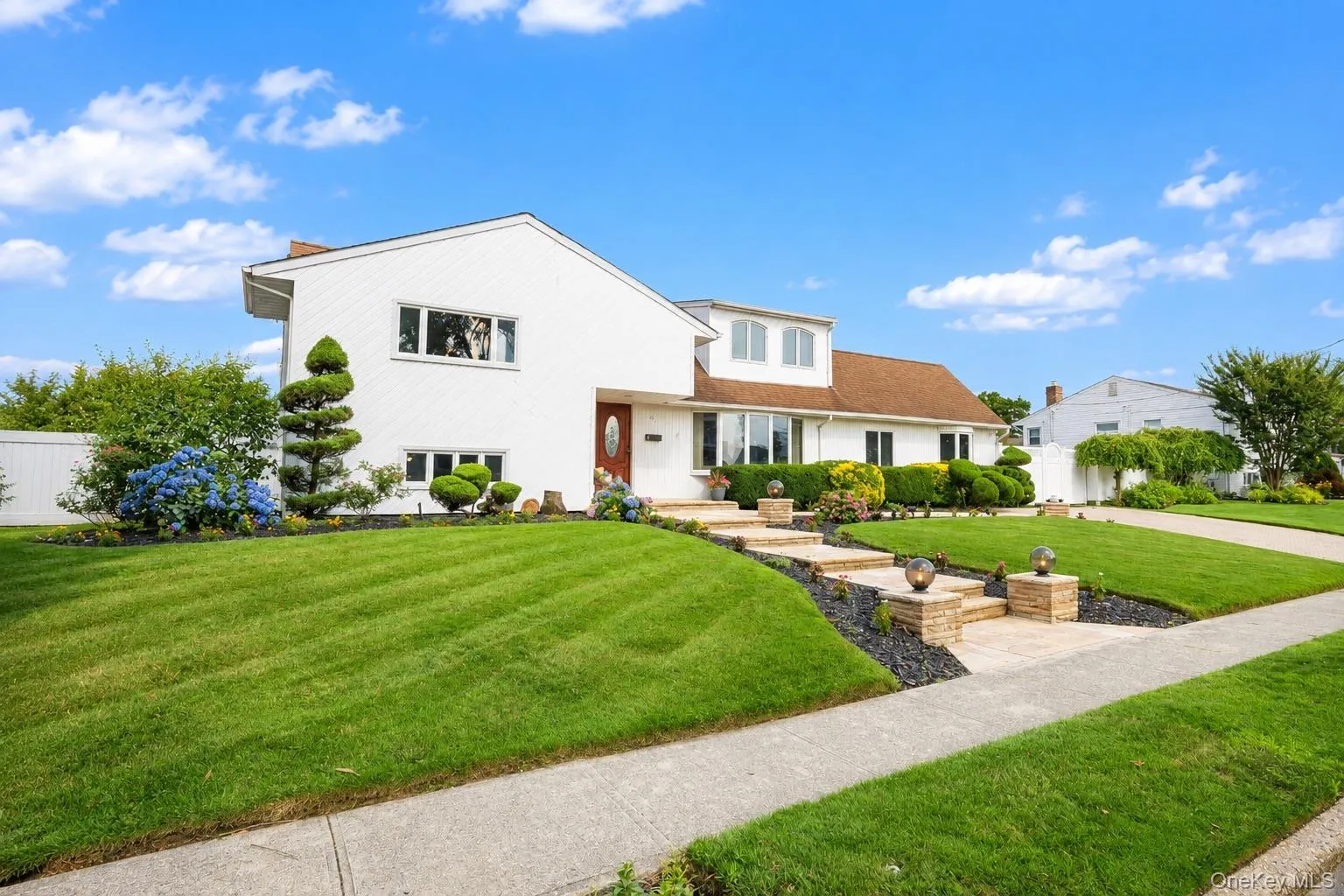 White exterior with gabled roofline and dormer window White exterior with gabled roofline and dormer window