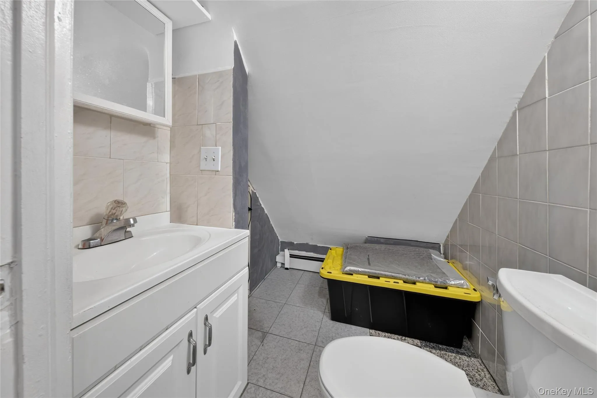 Bathroom featuring a white vanity with integrated sink, chrome faucet, white medicine cabinet, and tile flooring Bathroom featuring a white vanity with integrated sink, chrome faucet, white medicine cabinet, and tile flooring