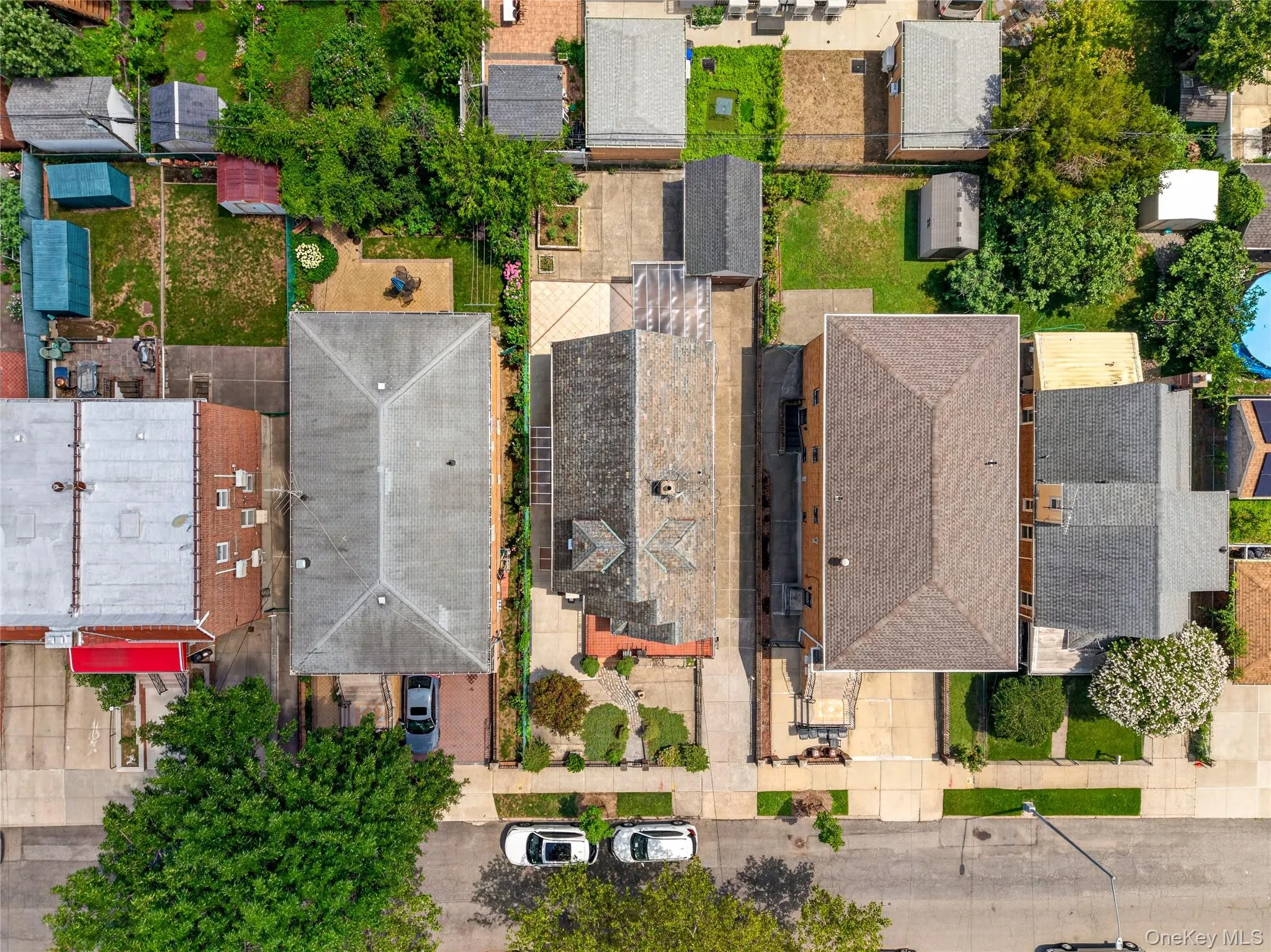 Aerial view showcasing the property's footprint, including a pitched roofline, paved driveway, and established landscaping Aerial view showcasing the property's footprint, including a pitched roofline, paved driveway, and established landscaping